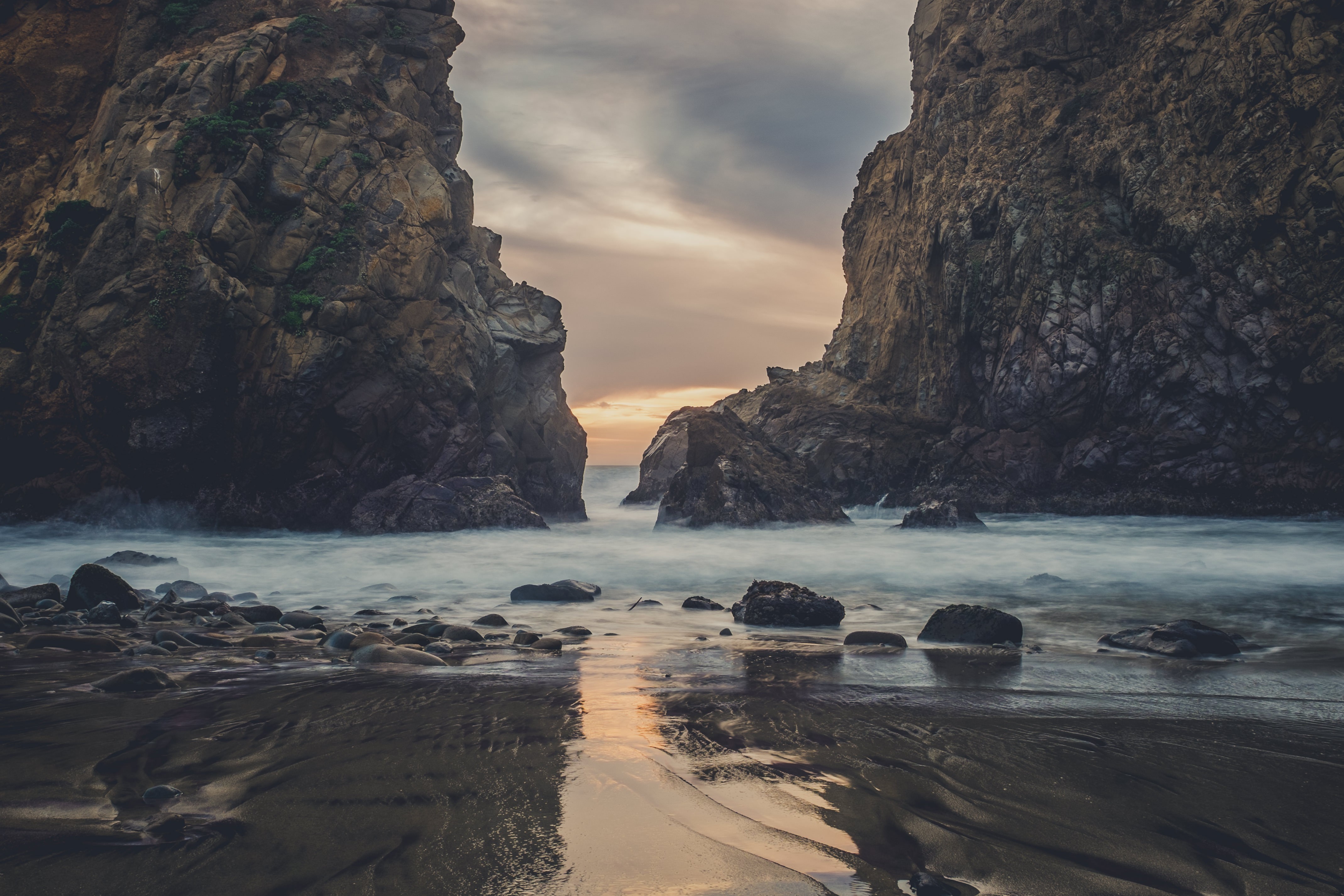 Rocky coastline with ocean waves at sunset HD Wallpaper