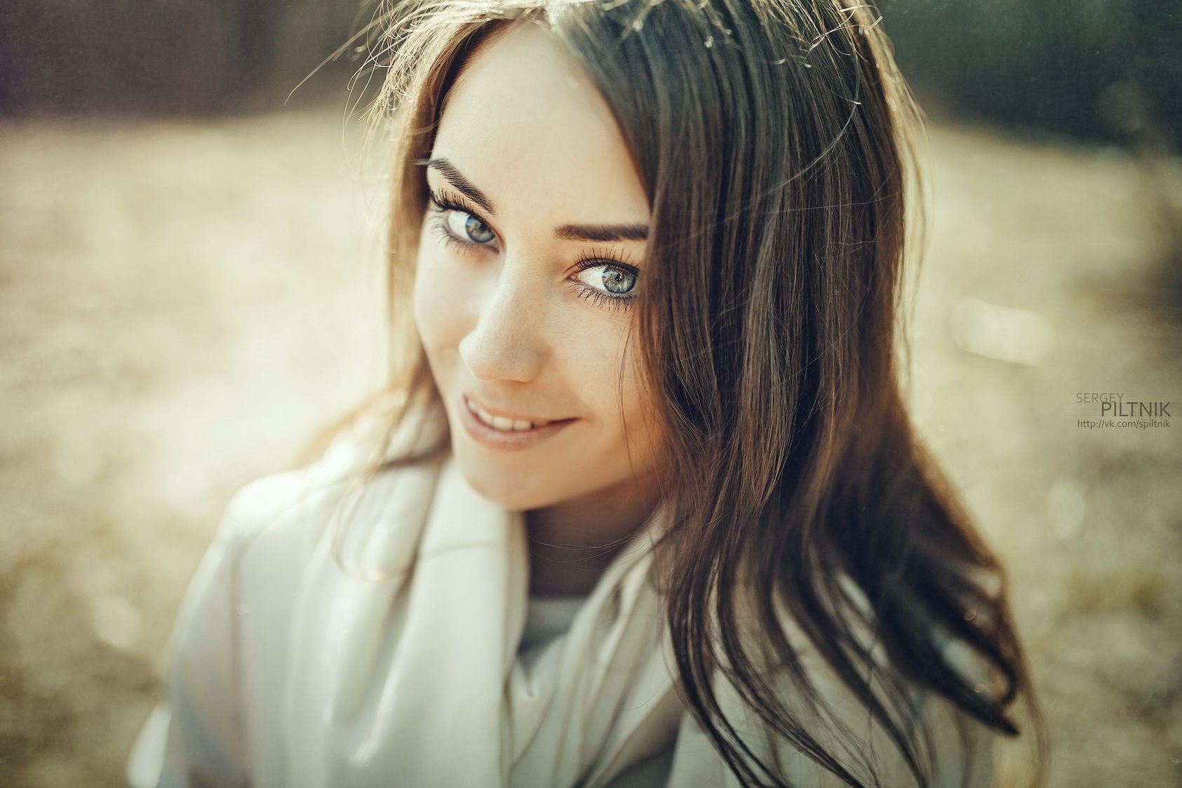 Brunette woman with blue eyes smiling outdoors HD Wallpaper