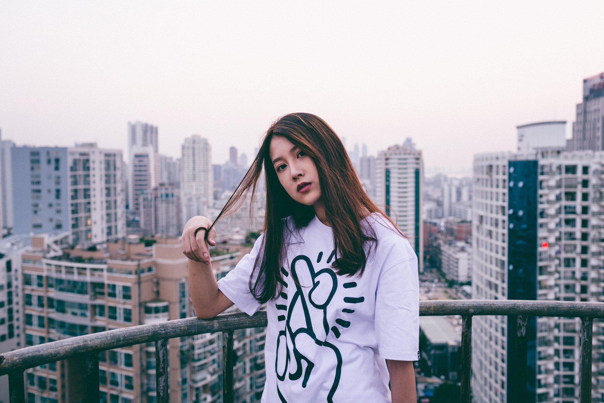 Woman on a balcony overlooking a cityscape in China HD Wallpaper