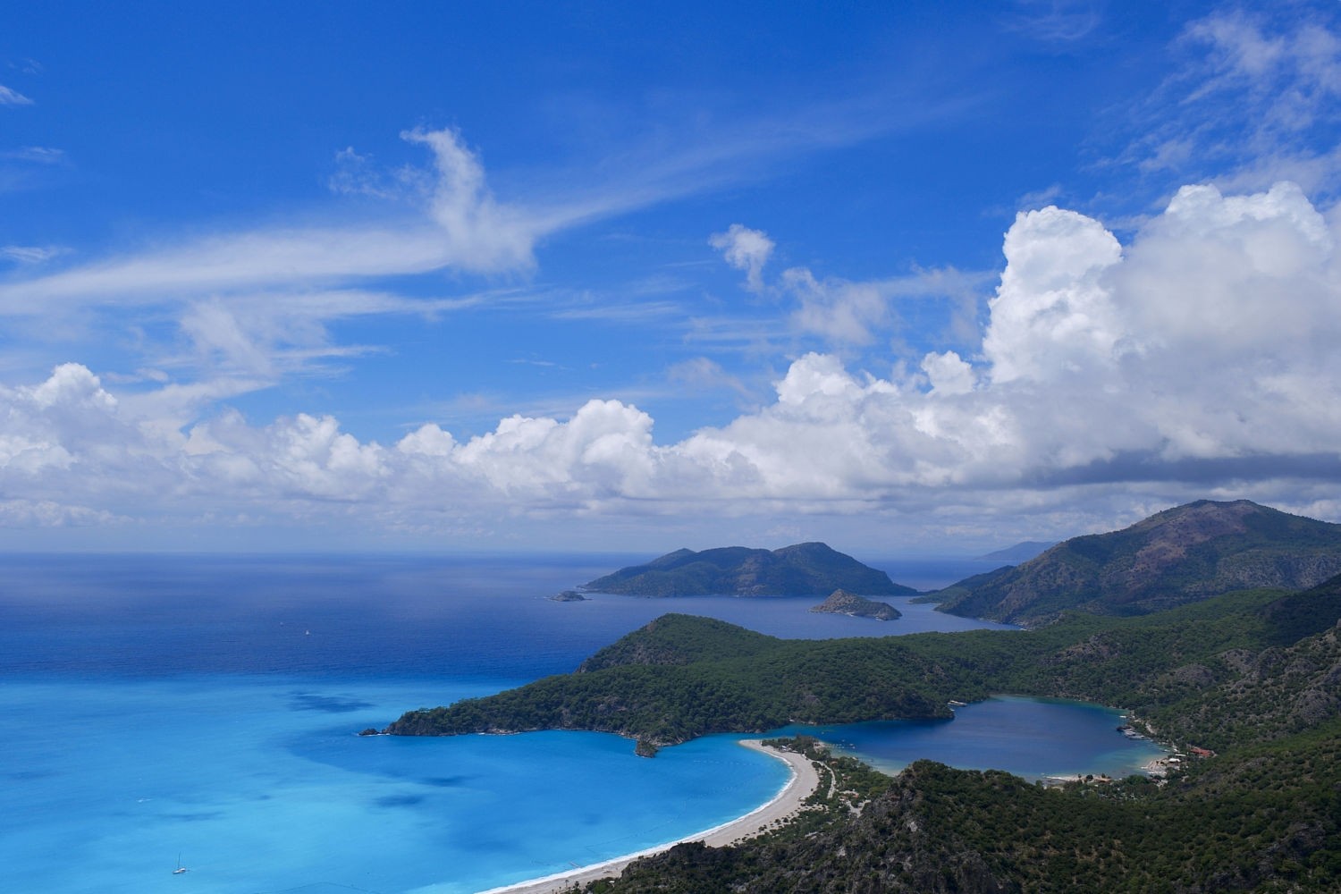 Coastal landscape with bay and hills under blue sky HD Wallpaper