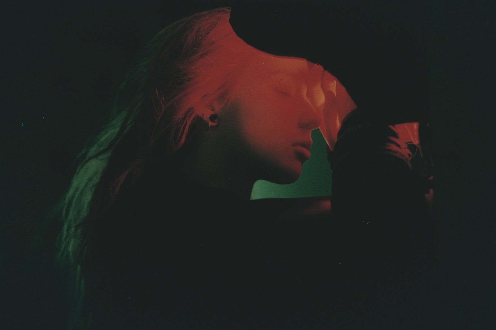 Woman with closed eyes illuminated by red and green lights HD Wallpaper