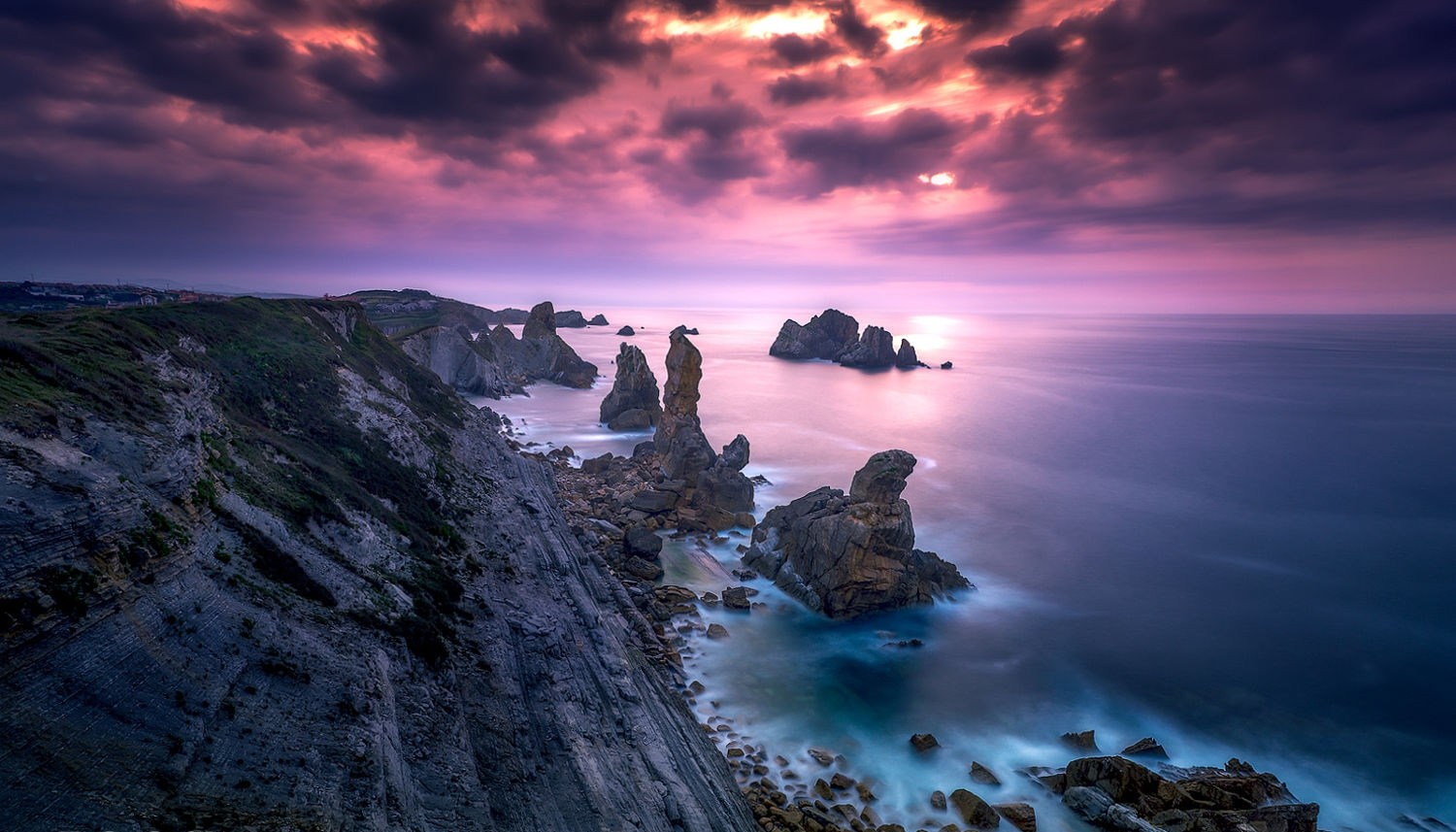 Dramatic sunset over rocky coast in Spain HD Wallpaper