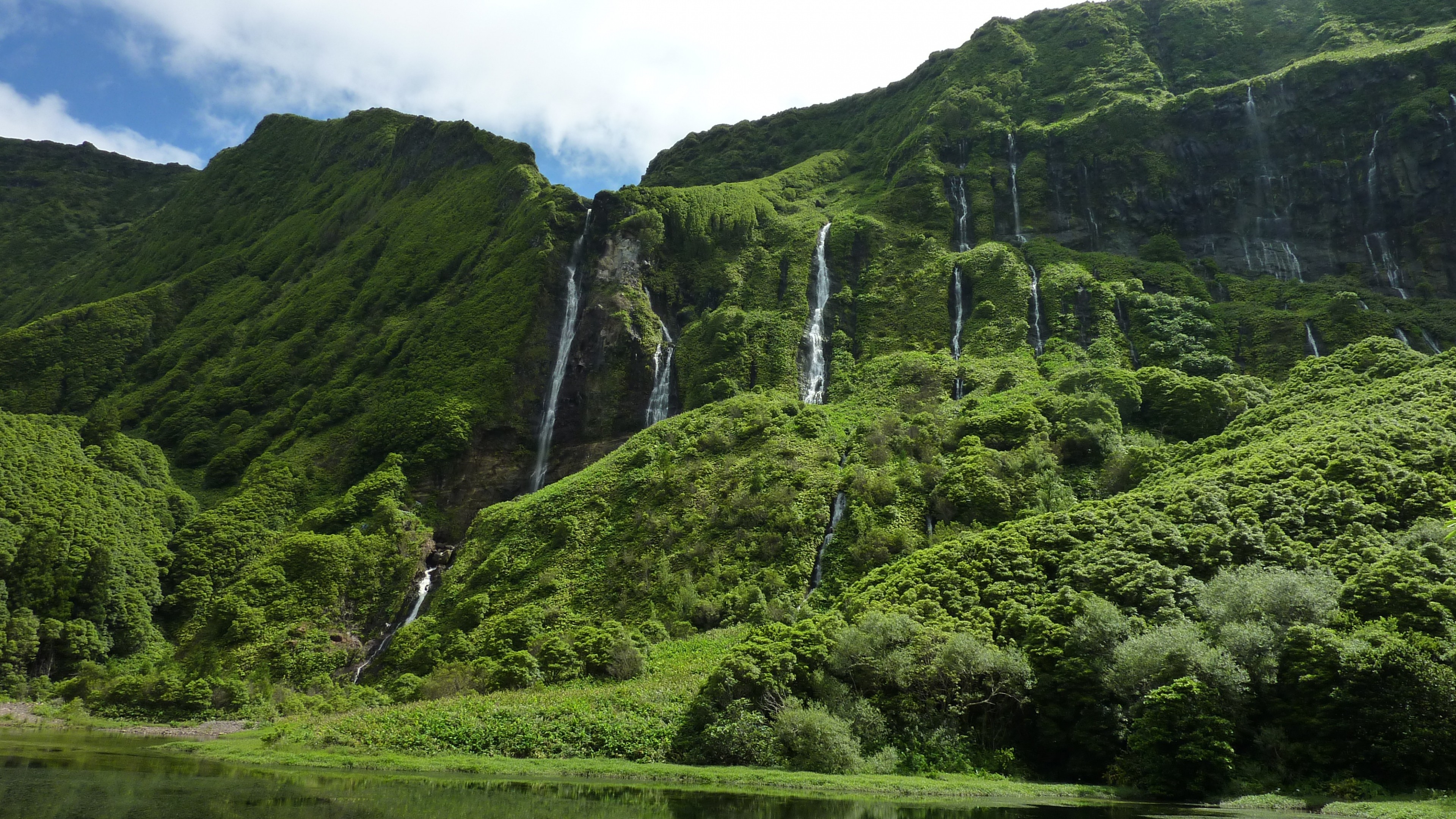 Green mountains with many waterfalls and a lake HD Wallpaper