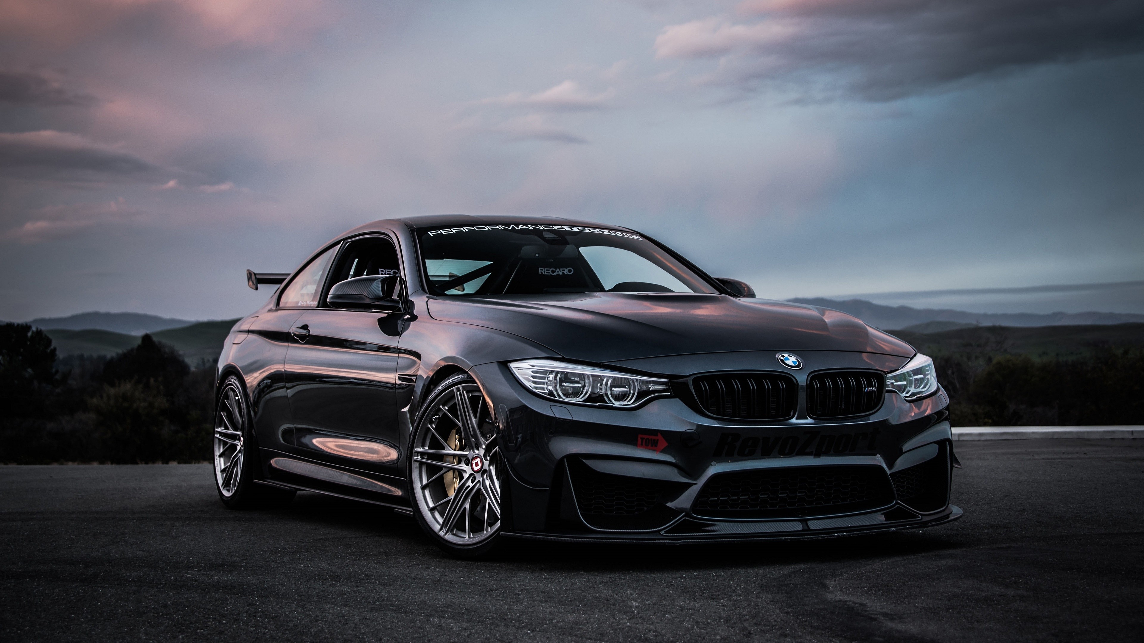 Dark BMW M4 sports car on a road HD Wallpaper