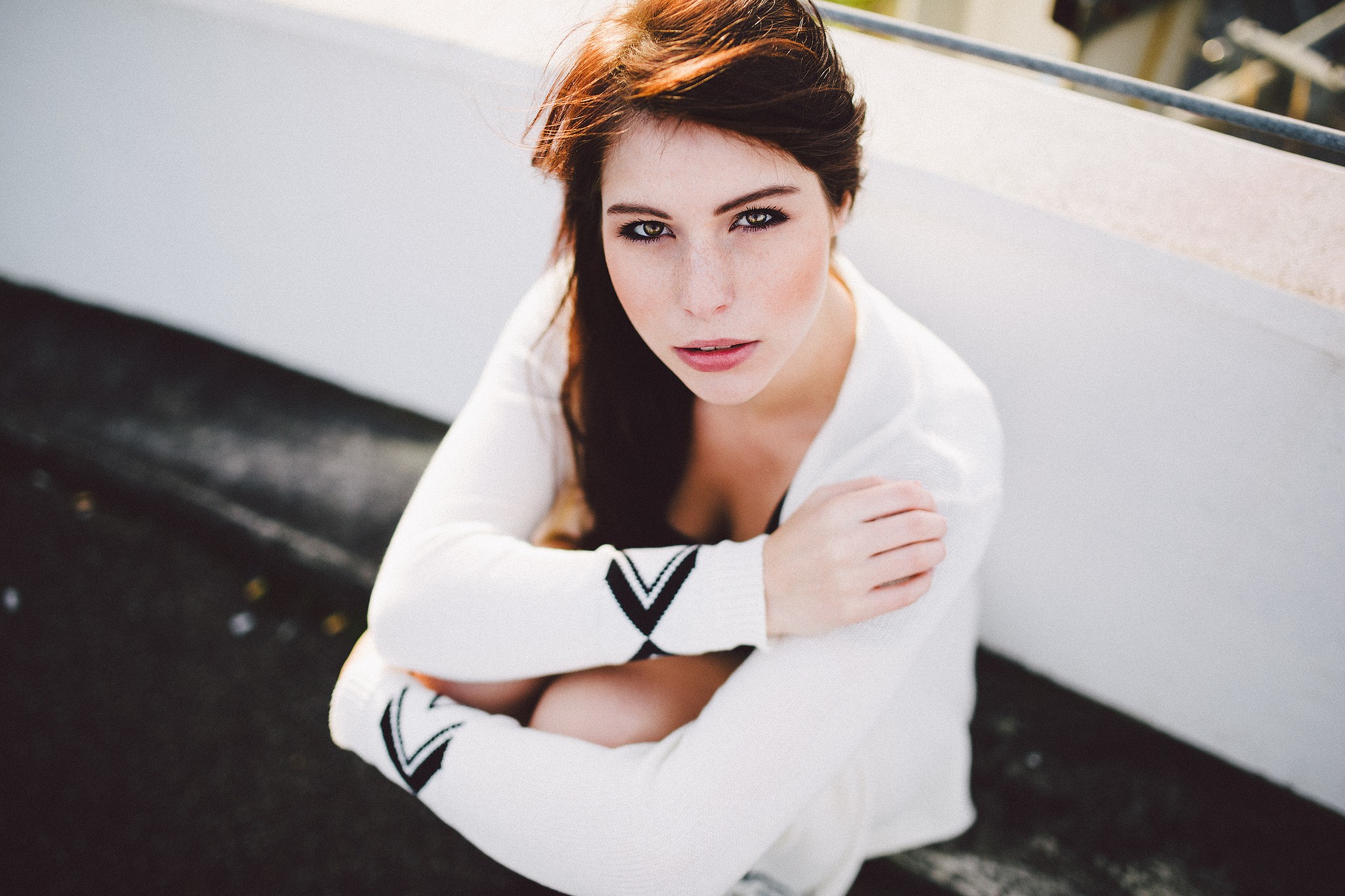 Woman with brunette hair sitting and looking at viewer HD Wallpaper