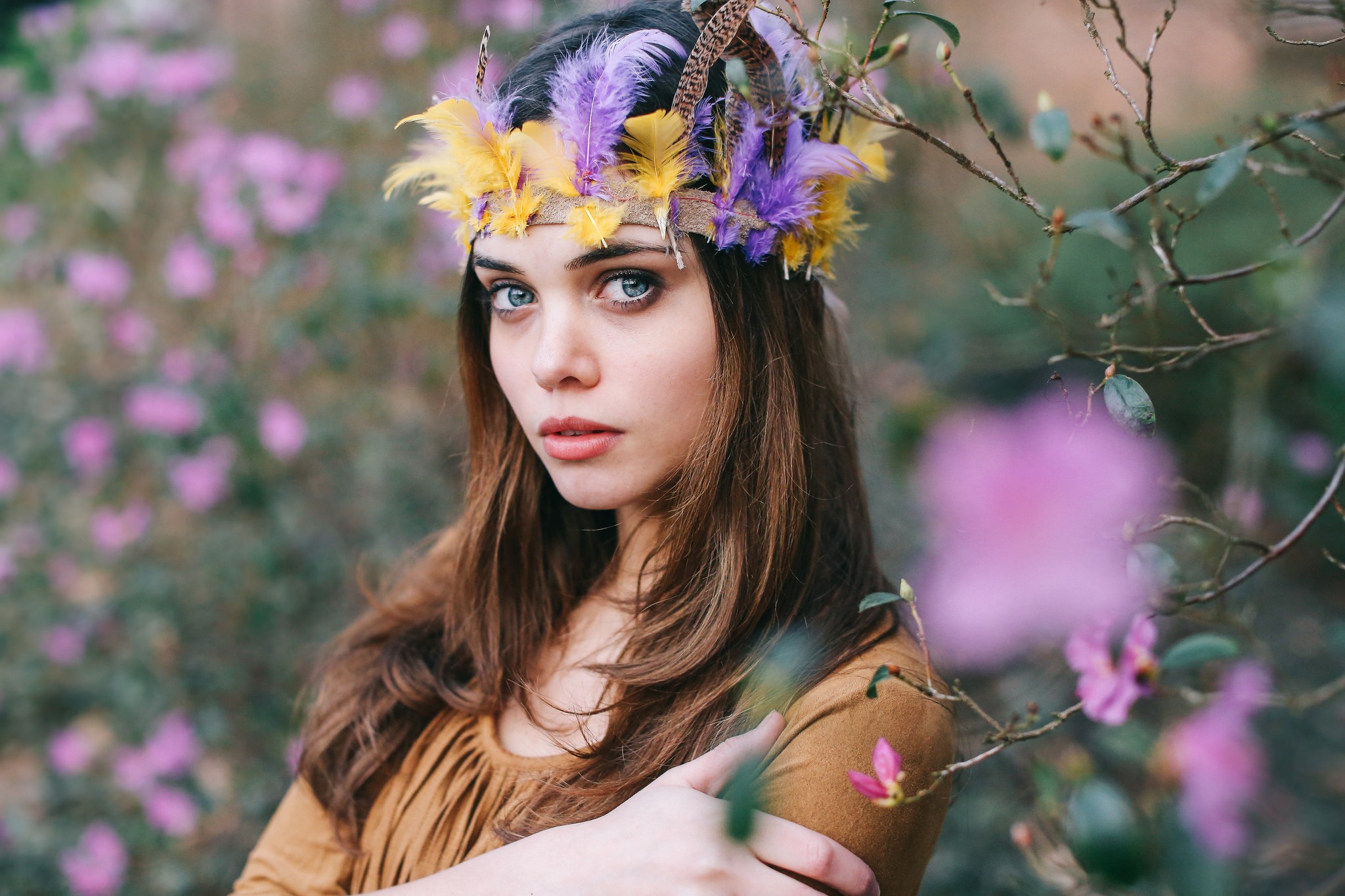 Woman with blue eyes and feather headband outdoors HD Wallpaper