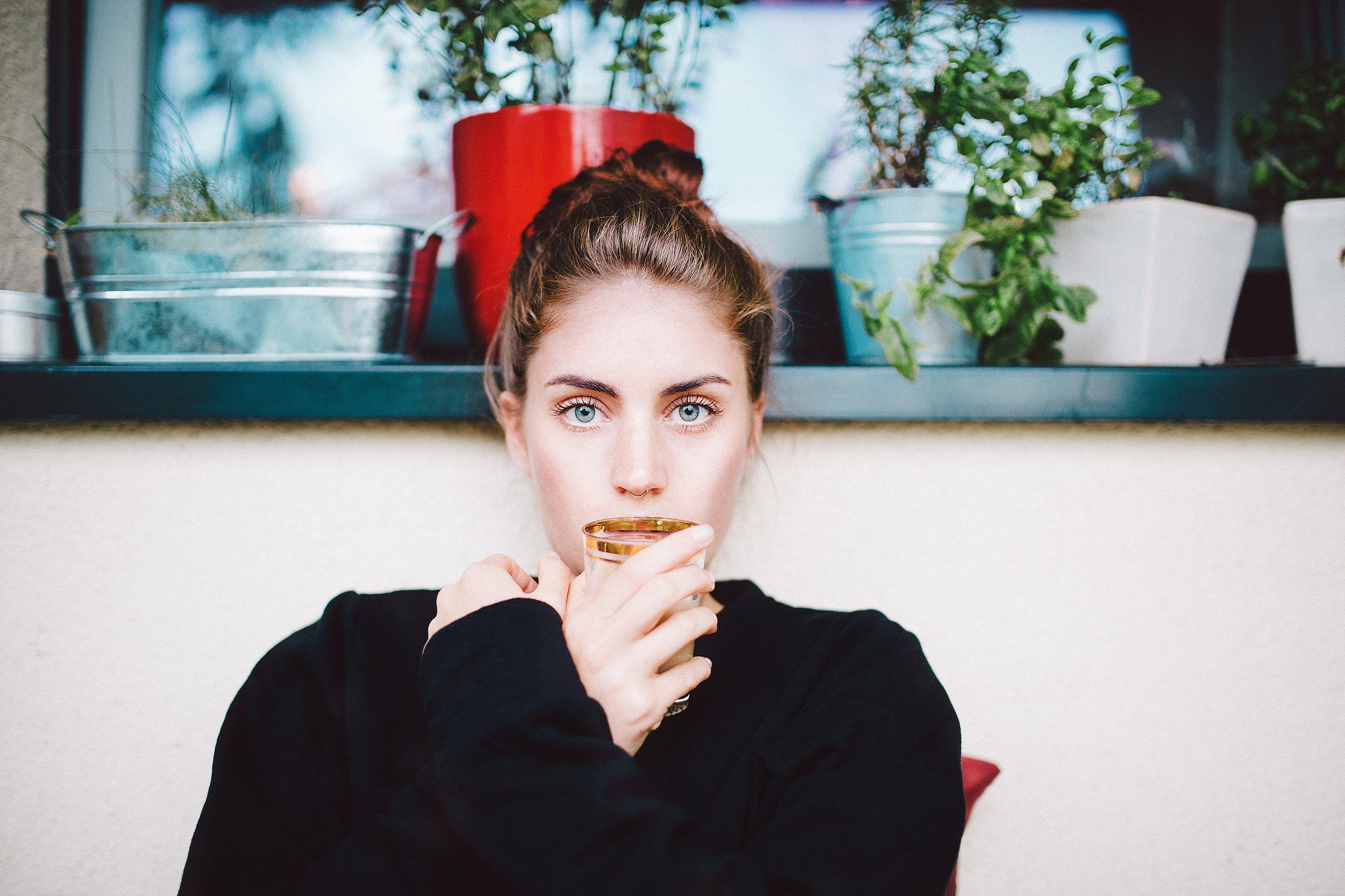 Woman with blue eyes drinking from a glass HD Wallpaper
