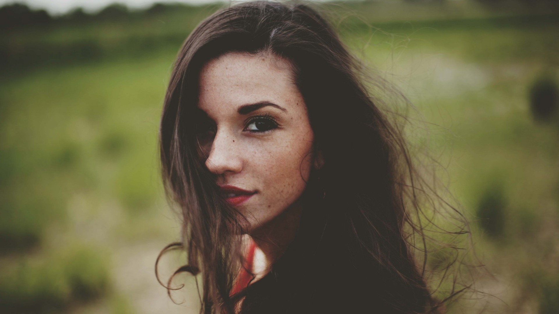 Woman with freckles and long brown hair outdoors HD Wallpaper