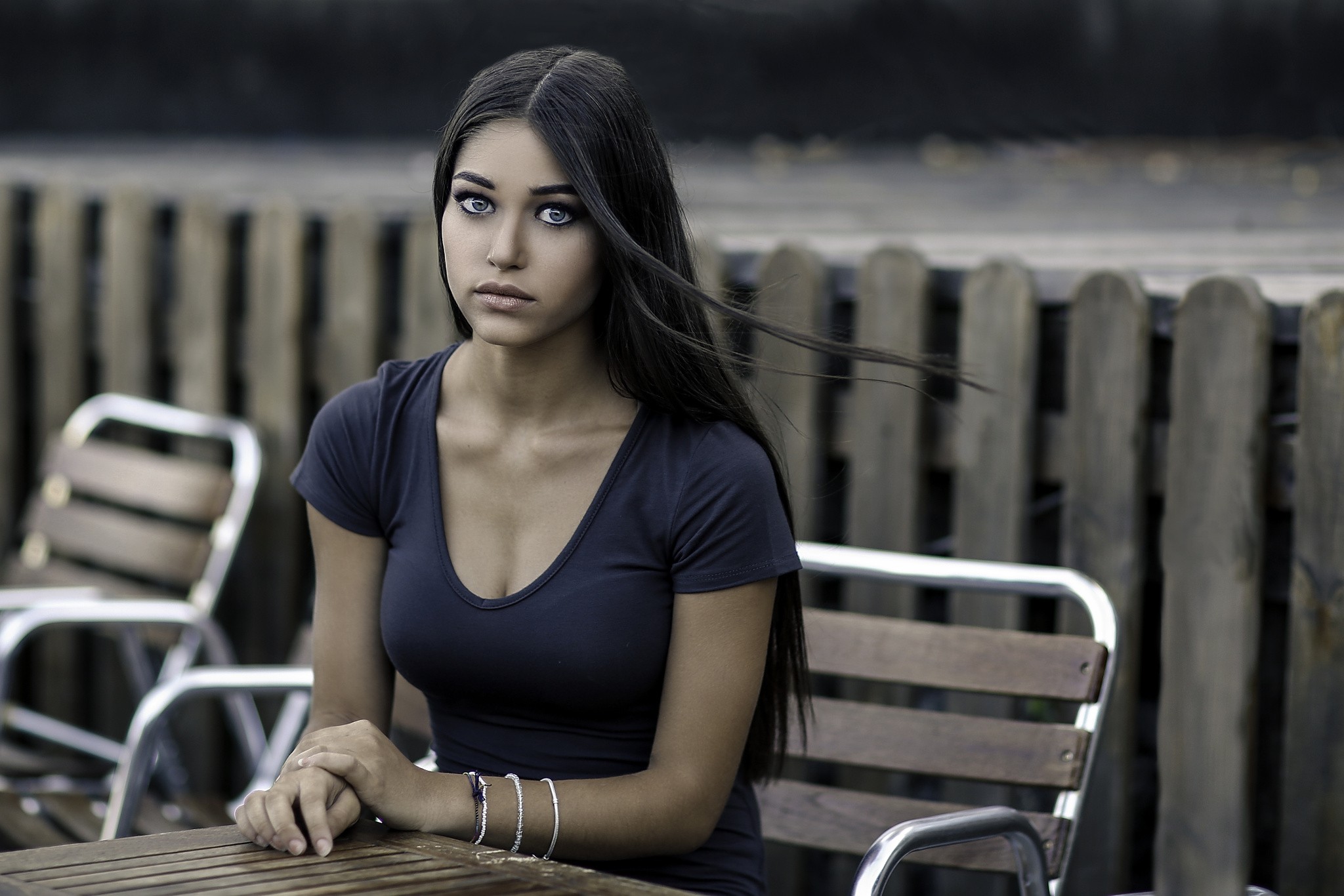 Woman with blue eyes sitting at a table HD Wallpaper
