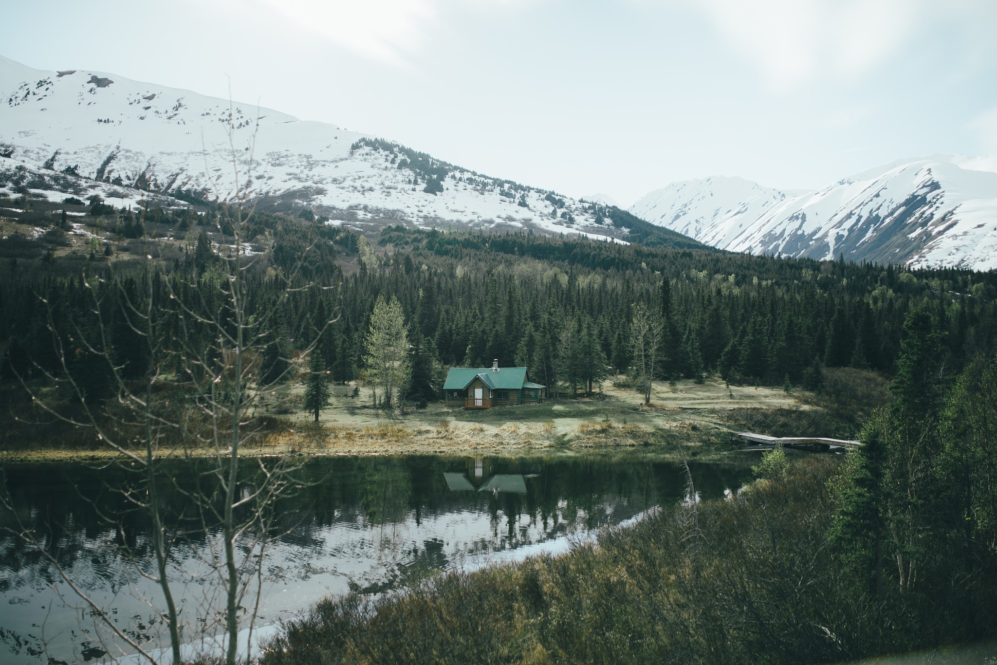 Cabin by a lake in a snowy mountain forest HD Wallpaper