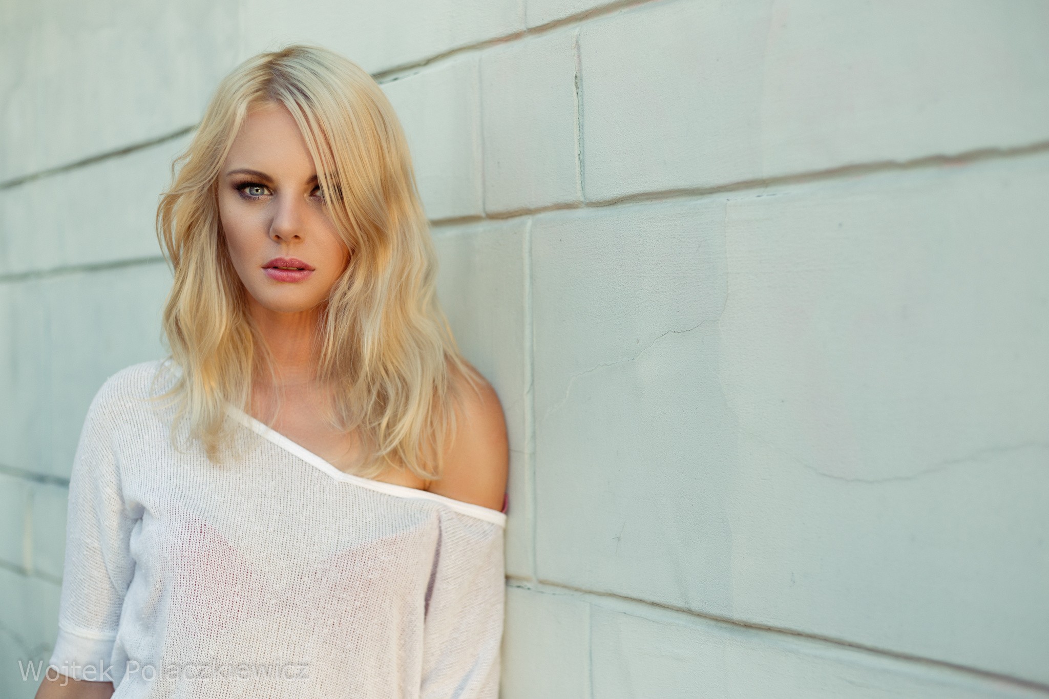 Woman with blonde hair leaning against a wall HD Wallpaper