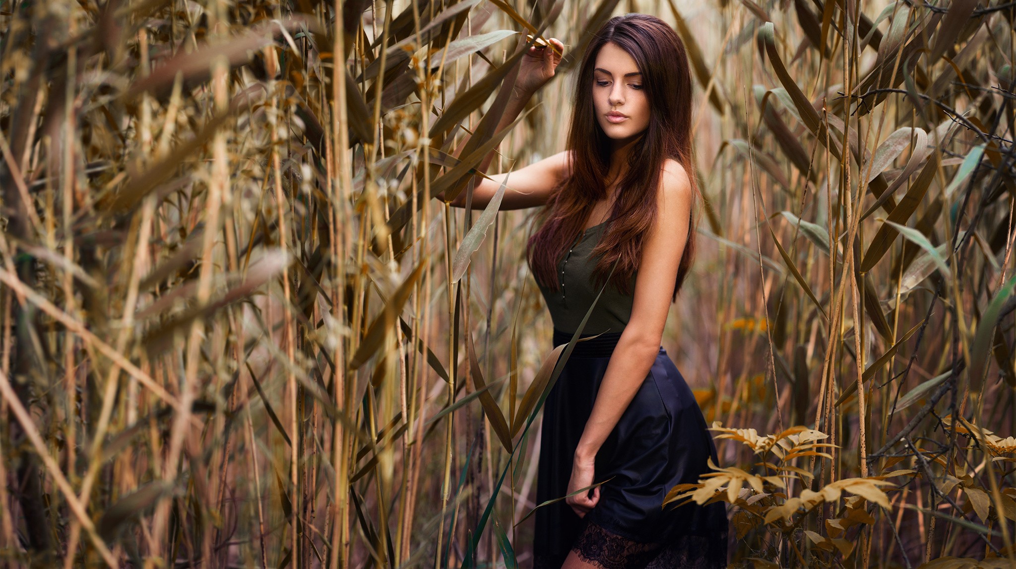 Woman in a skirt standing in tall grass HD Wallpaper