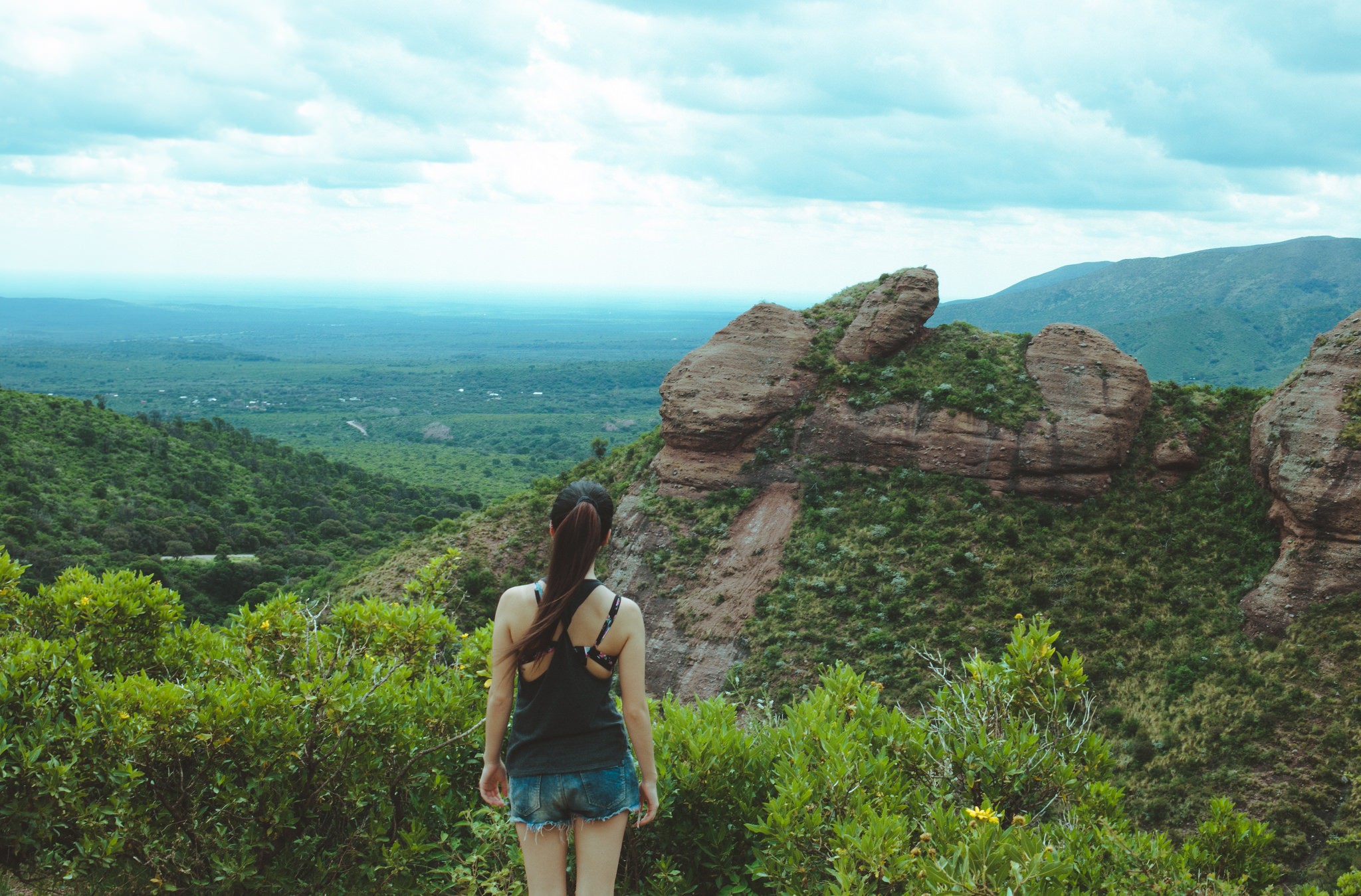 Woman with ponytail looking at a mountain landscape HD Wallpaper
