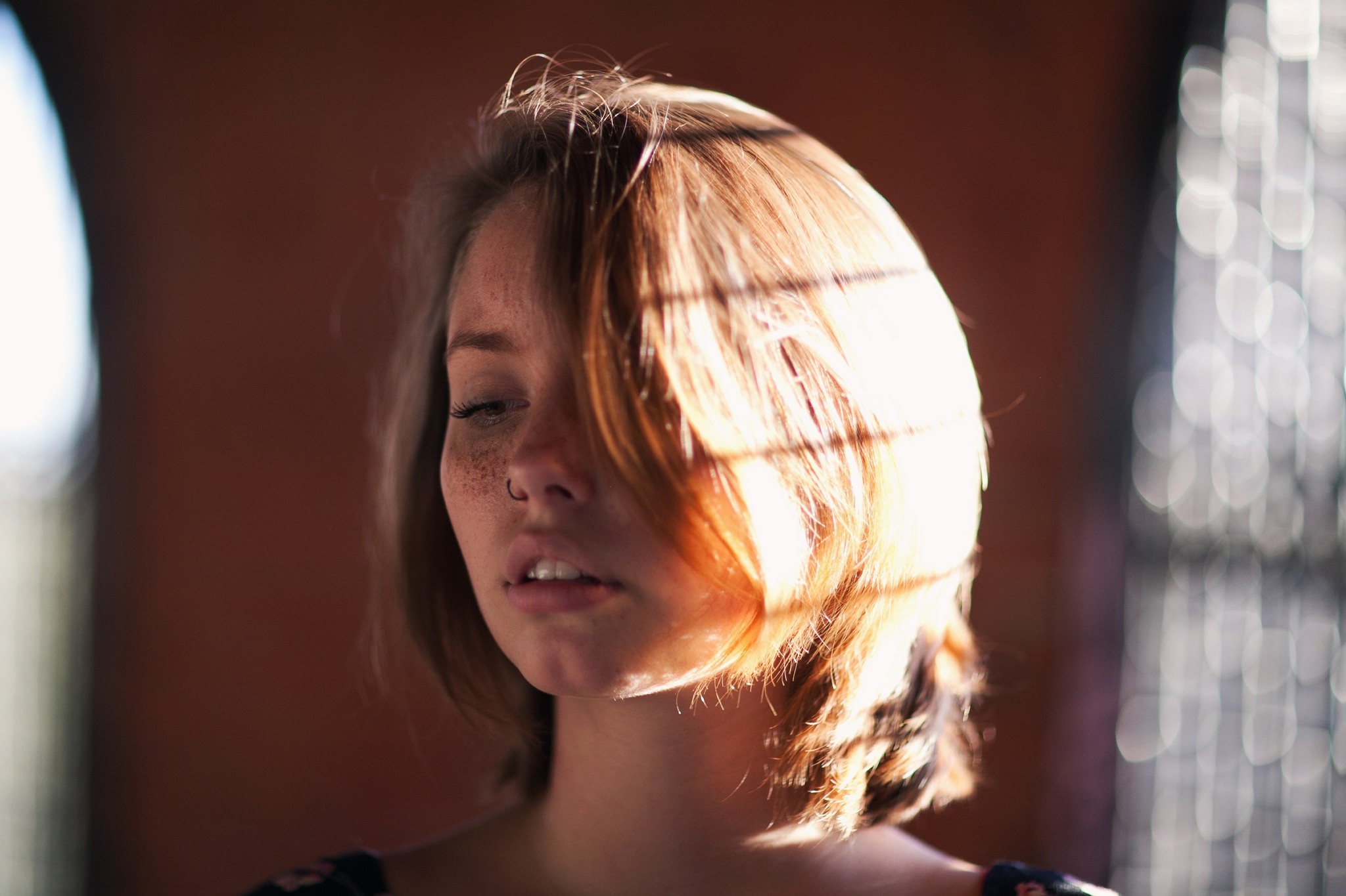 Woman with freckles and nose ring in sunlight HD Wallpaper