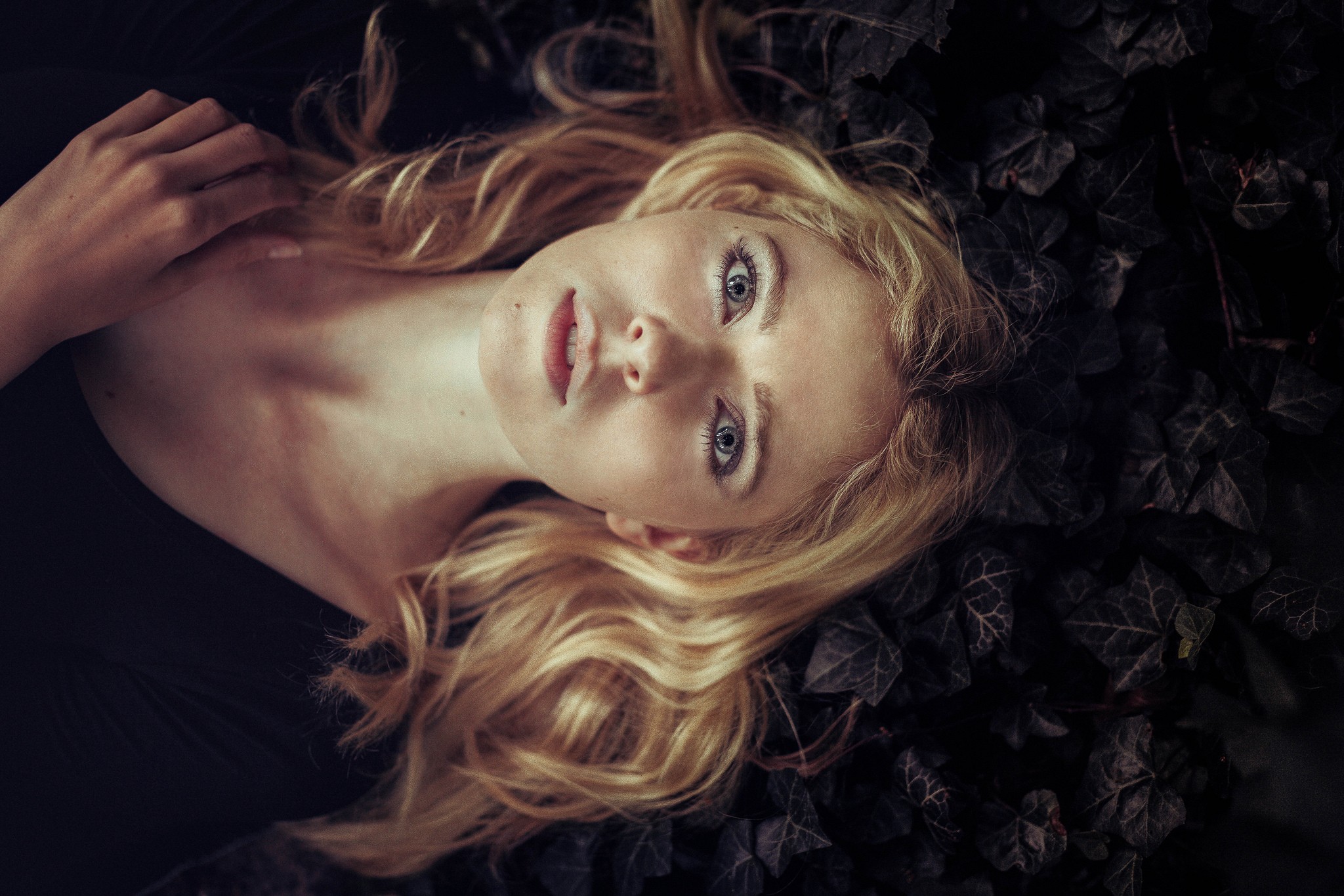 Woman with blonde wavy hair and blue eyes lying down HD Wallpaper