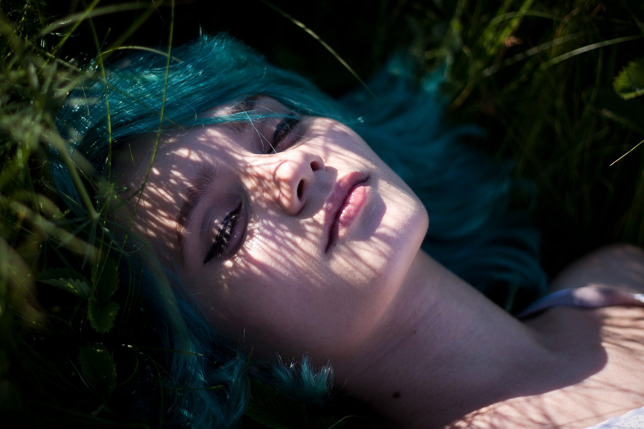 Woman with blue dyed hair lying in grass HD Wallpaper