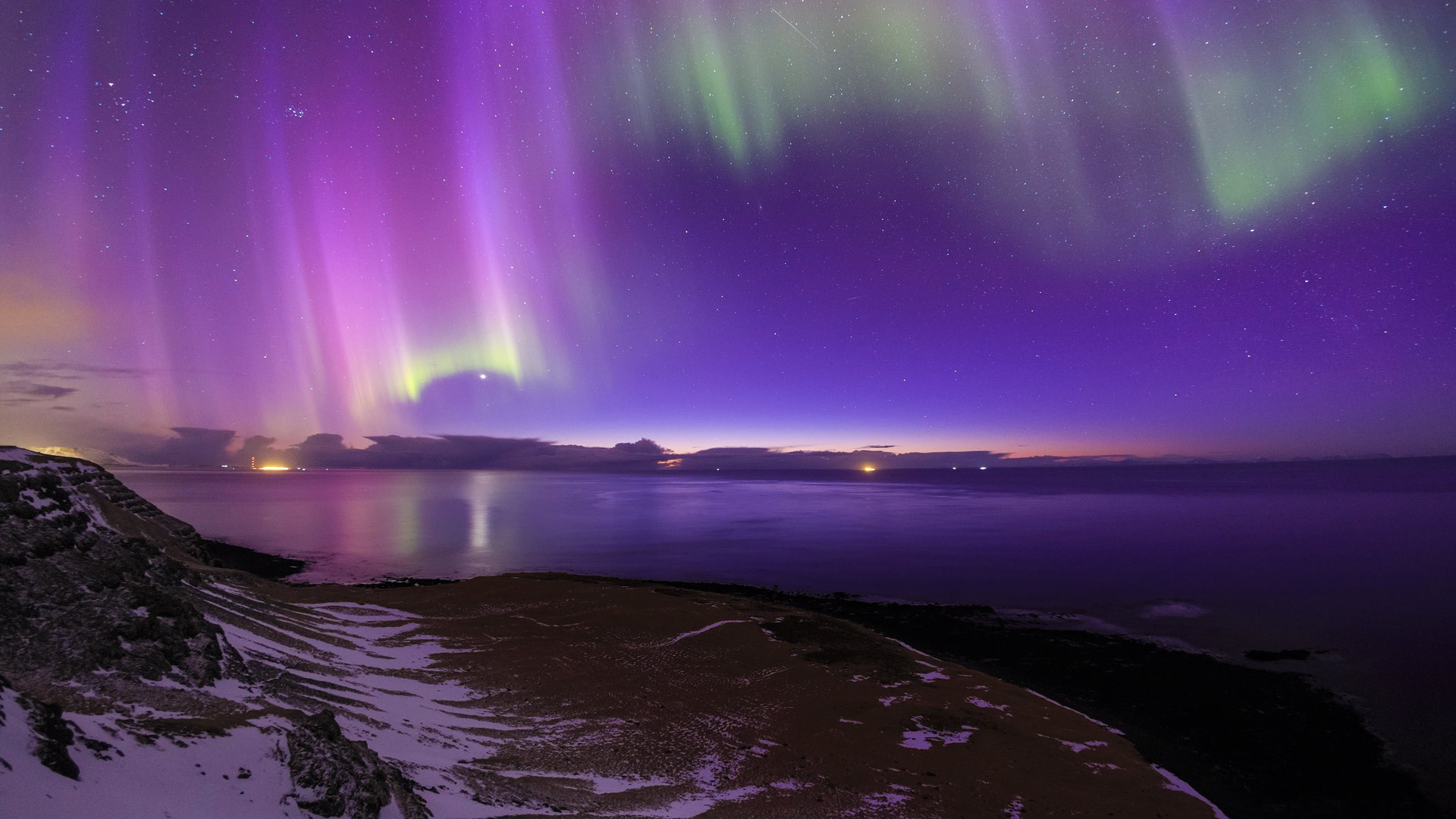 Aurora Borealis over a snowy landscape and ocean HD Wallpaper