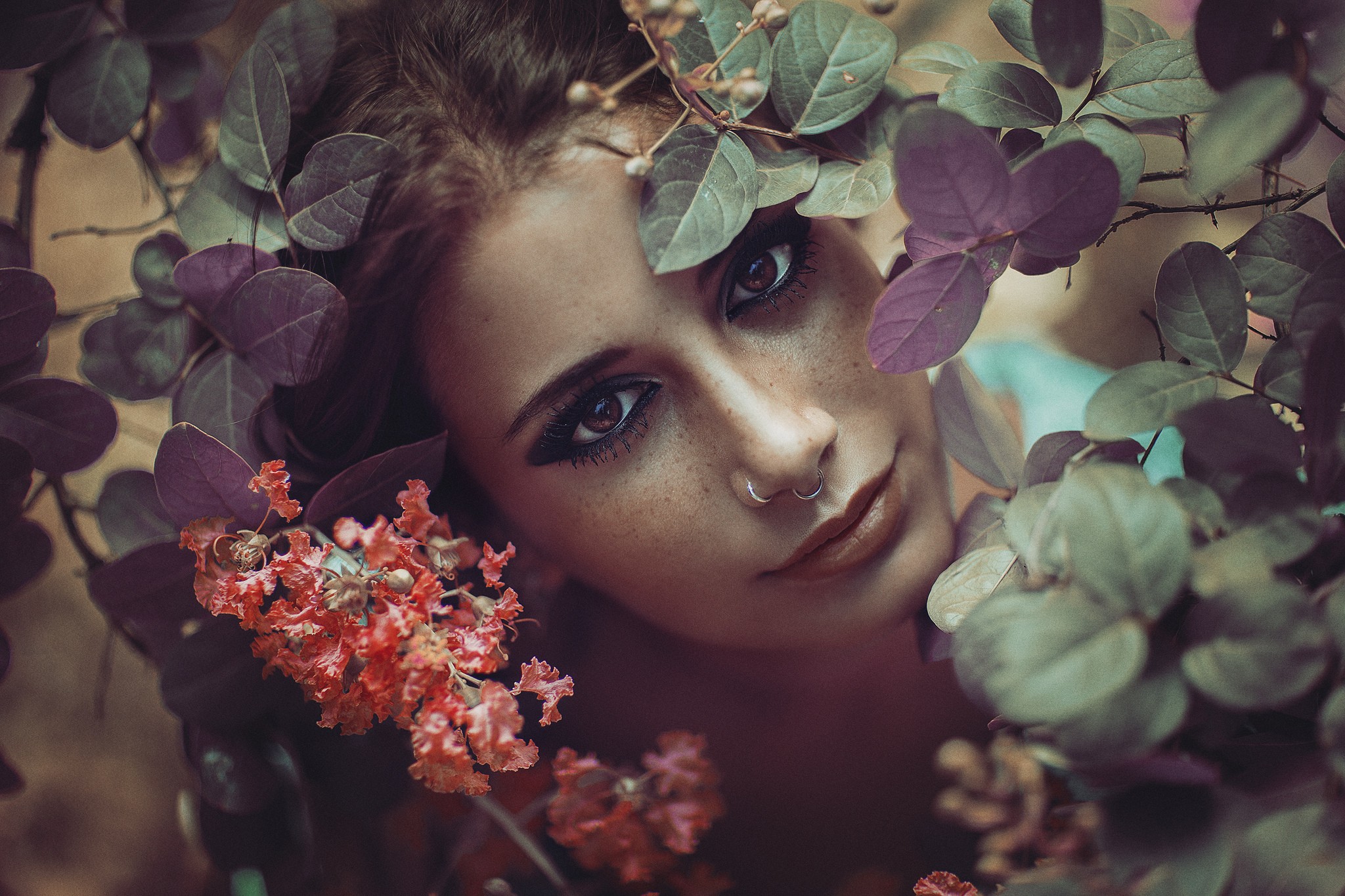 Woman with nose ring surrounded by plants HD Wallpaper