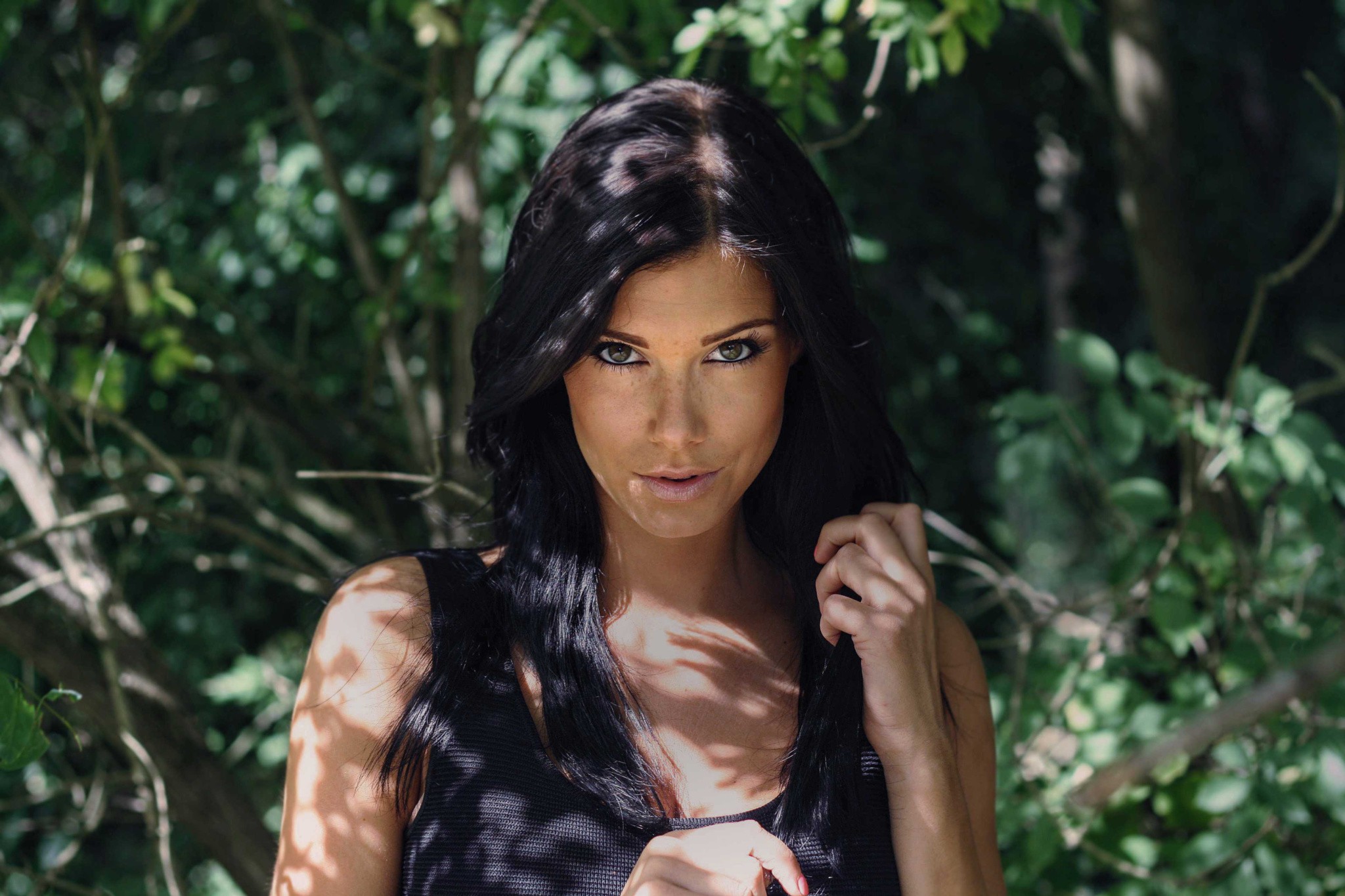Woman with black hair and freckles in dappled sunlight HD Wallpaper