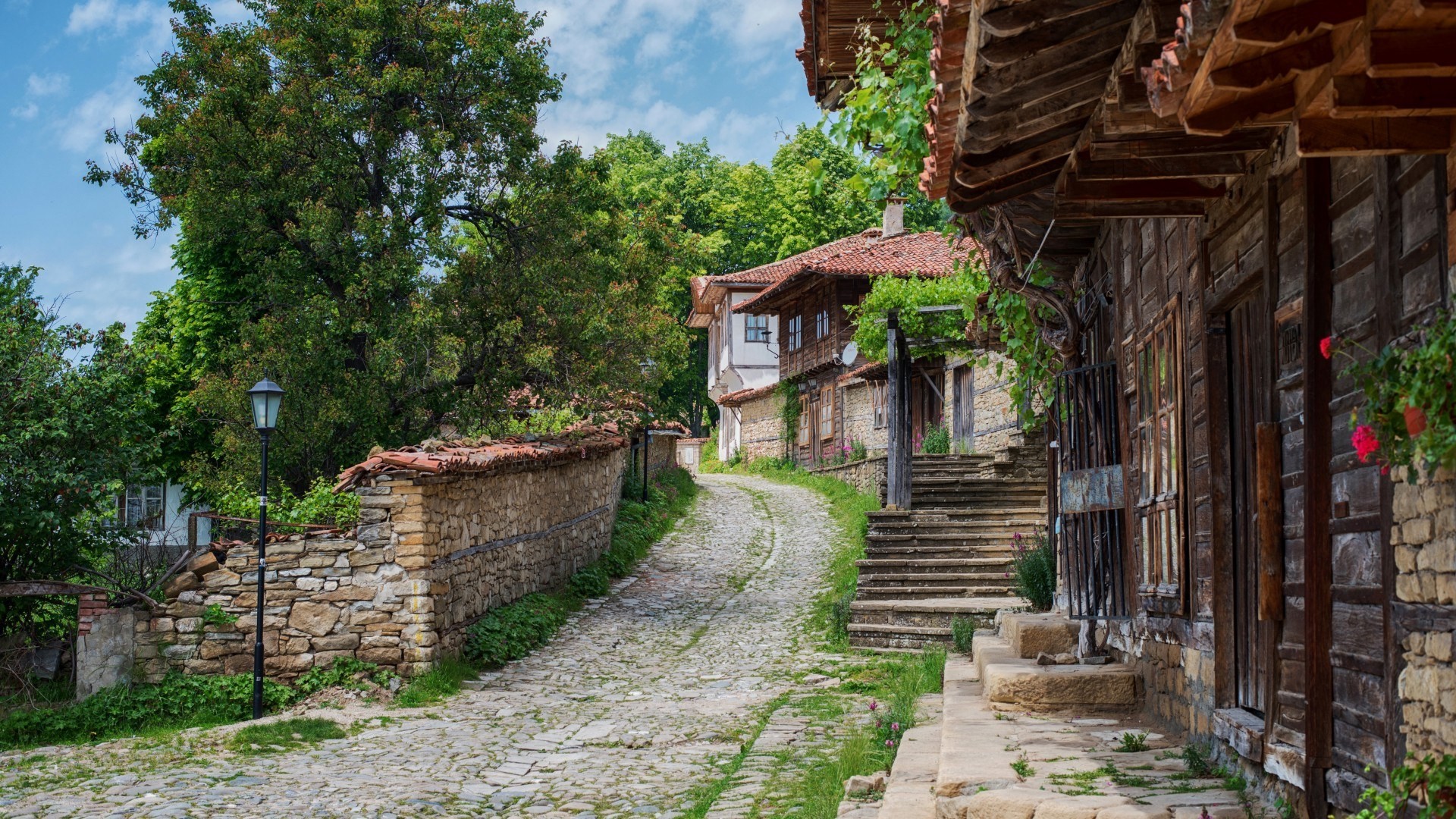 Cobblestone street in a Bulgarian village with stone walls and houses HD Wallpaper