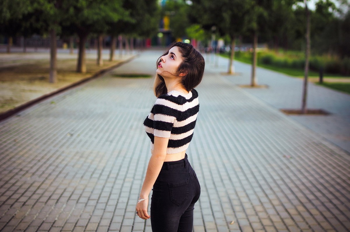 Woman in striped crop top and black jeans looking up HD Wallpaper