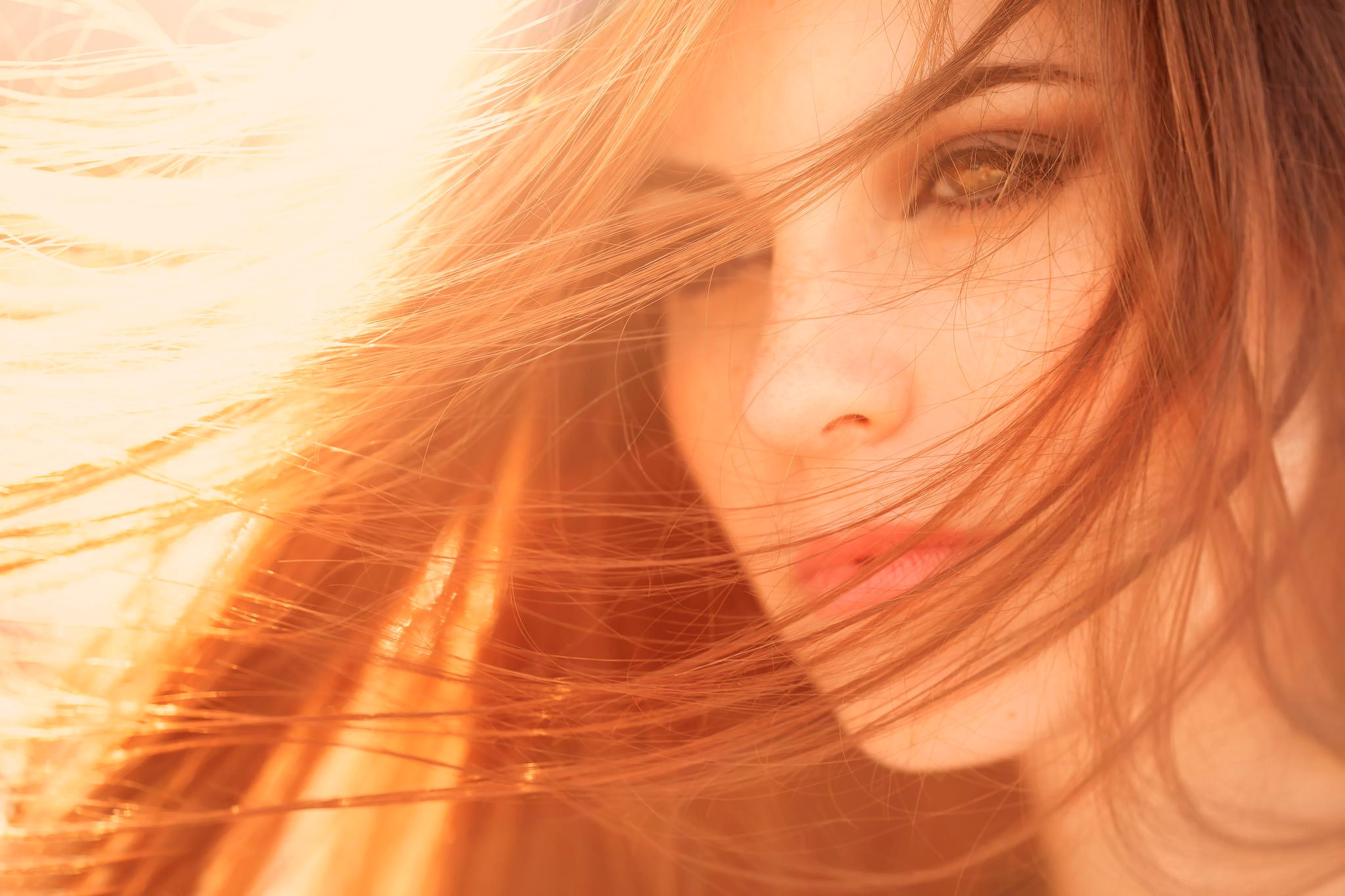 Close-up of a woman's face with hair blowing HD Wallpaper