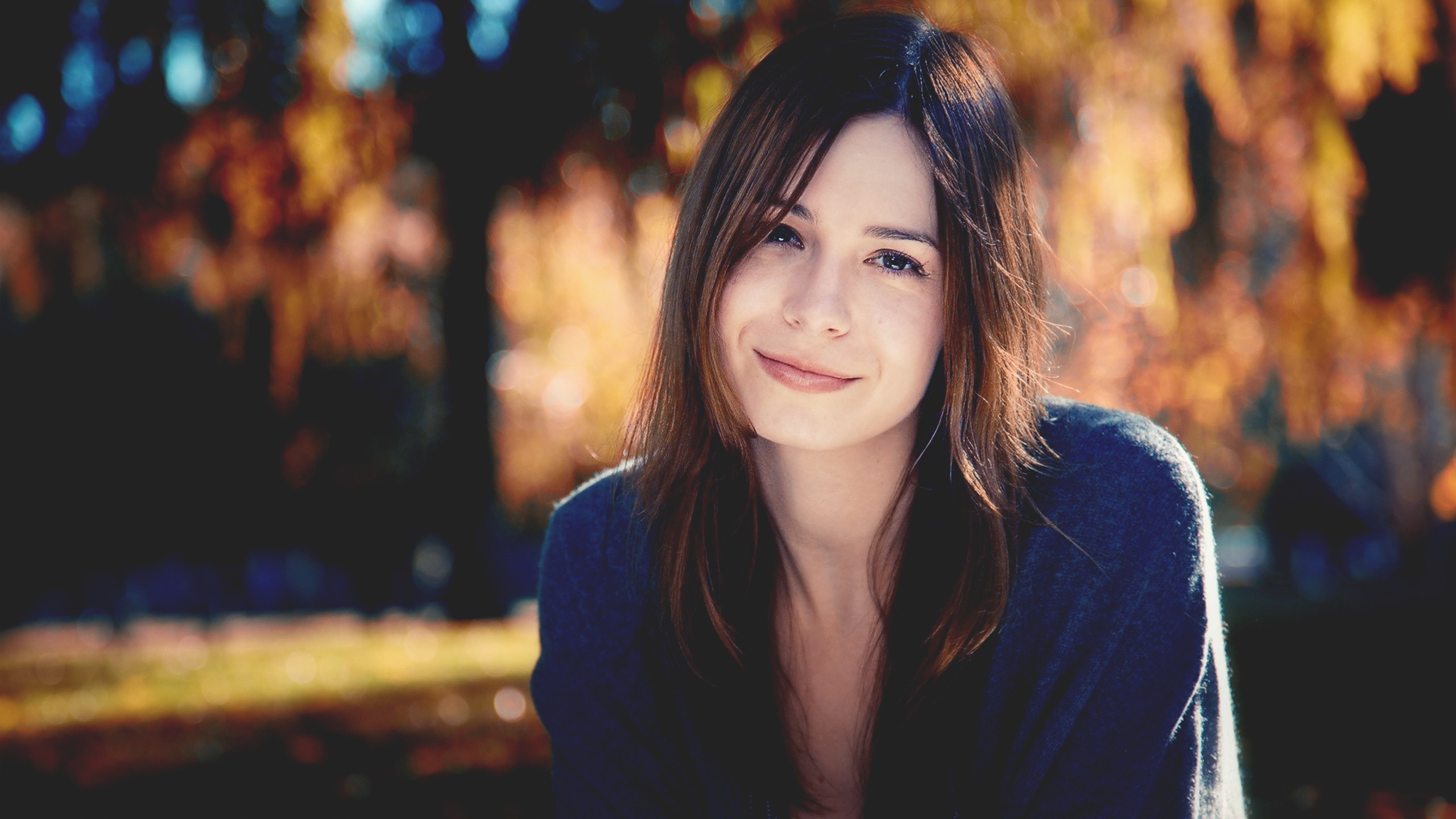 Woman smiling in a park during fall HD Wallpaper