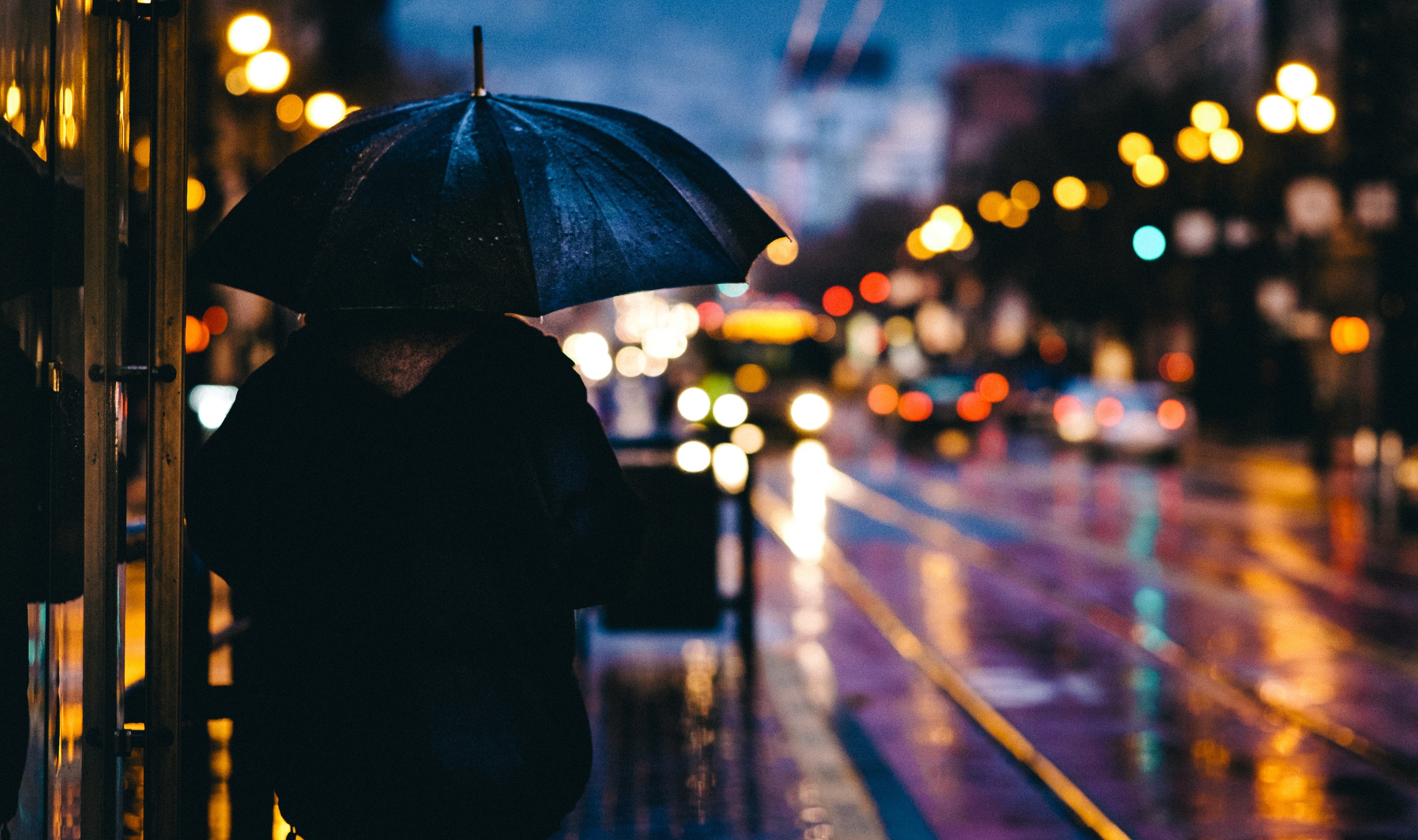 Person with umbrella in a rainy city at night HD Wallpaper