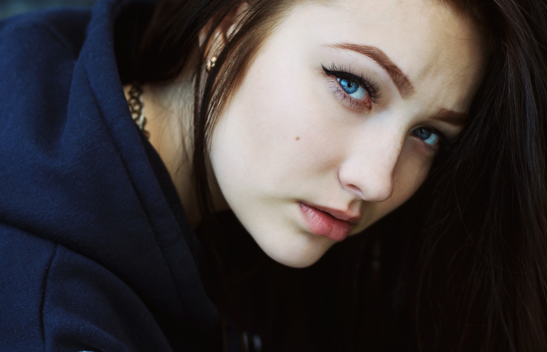 Woman with blue eyes wearing a dark hoodie HD Wallpaper