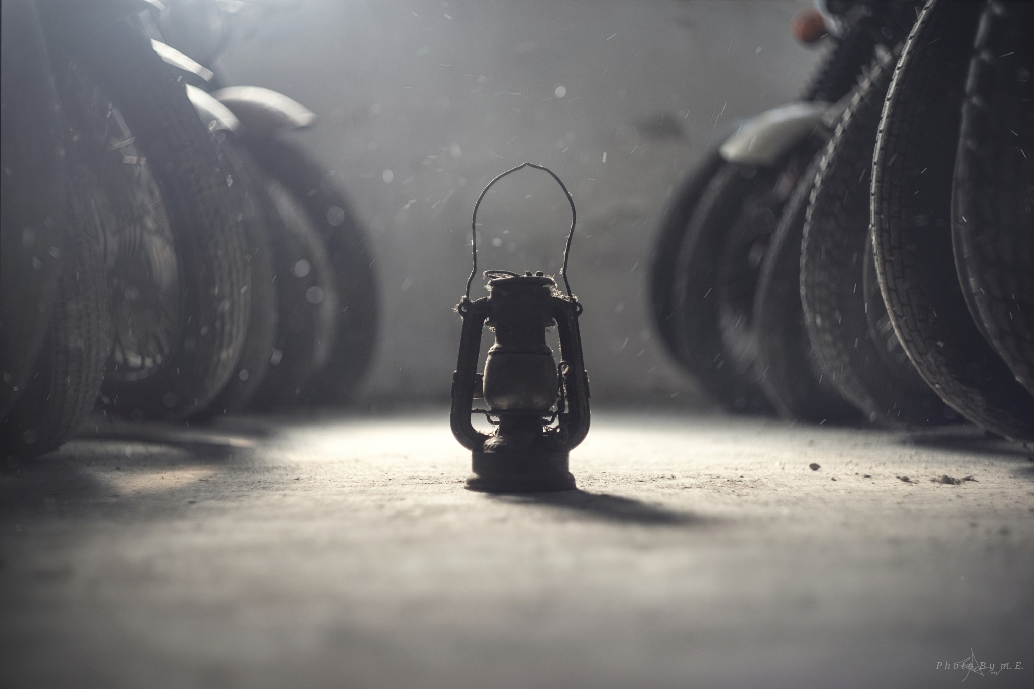 Old lantern between motorcycle tires HD Wallpaper