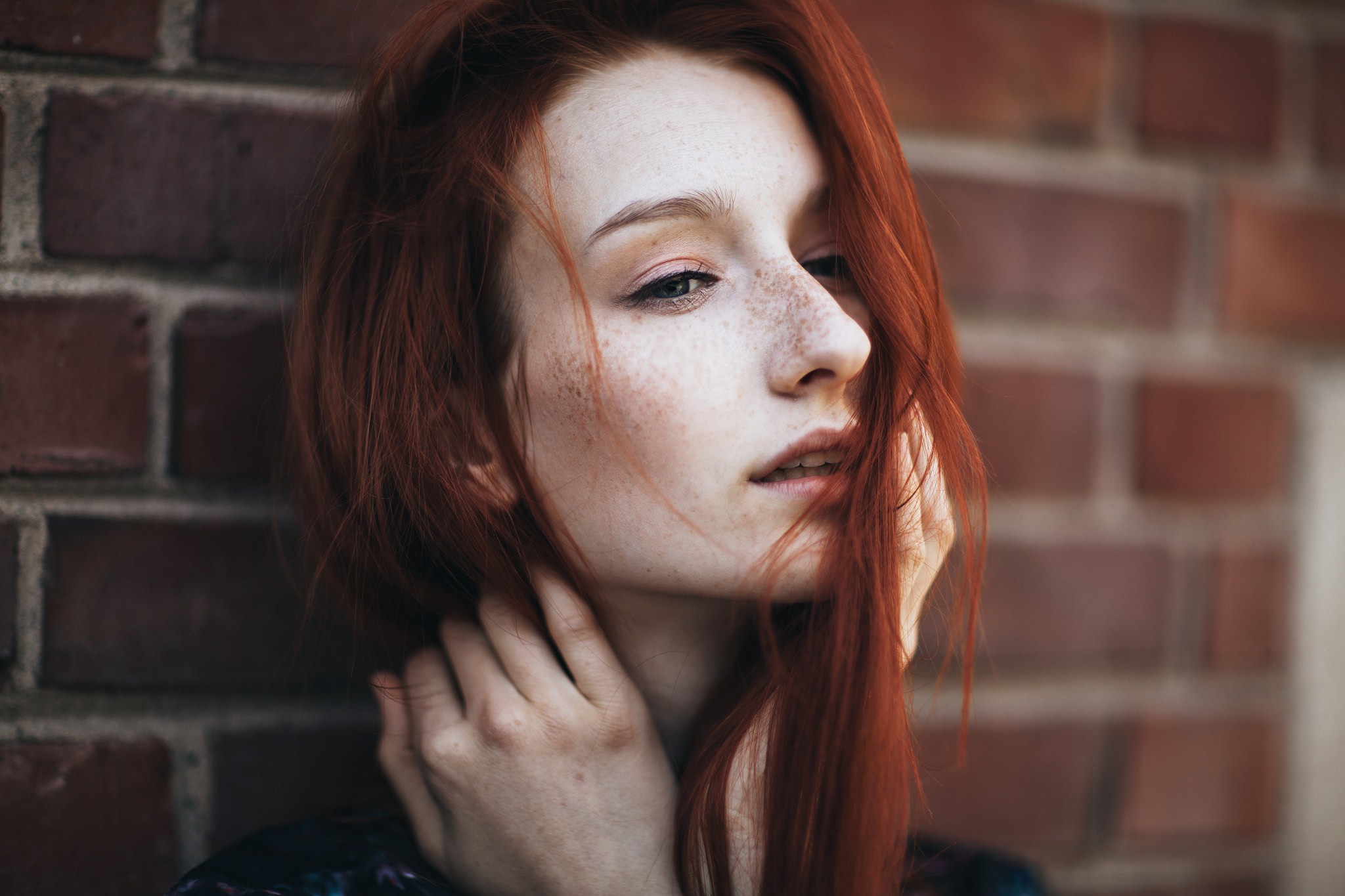 Redhead woman with freckles against brick wall HD Wallpaper
