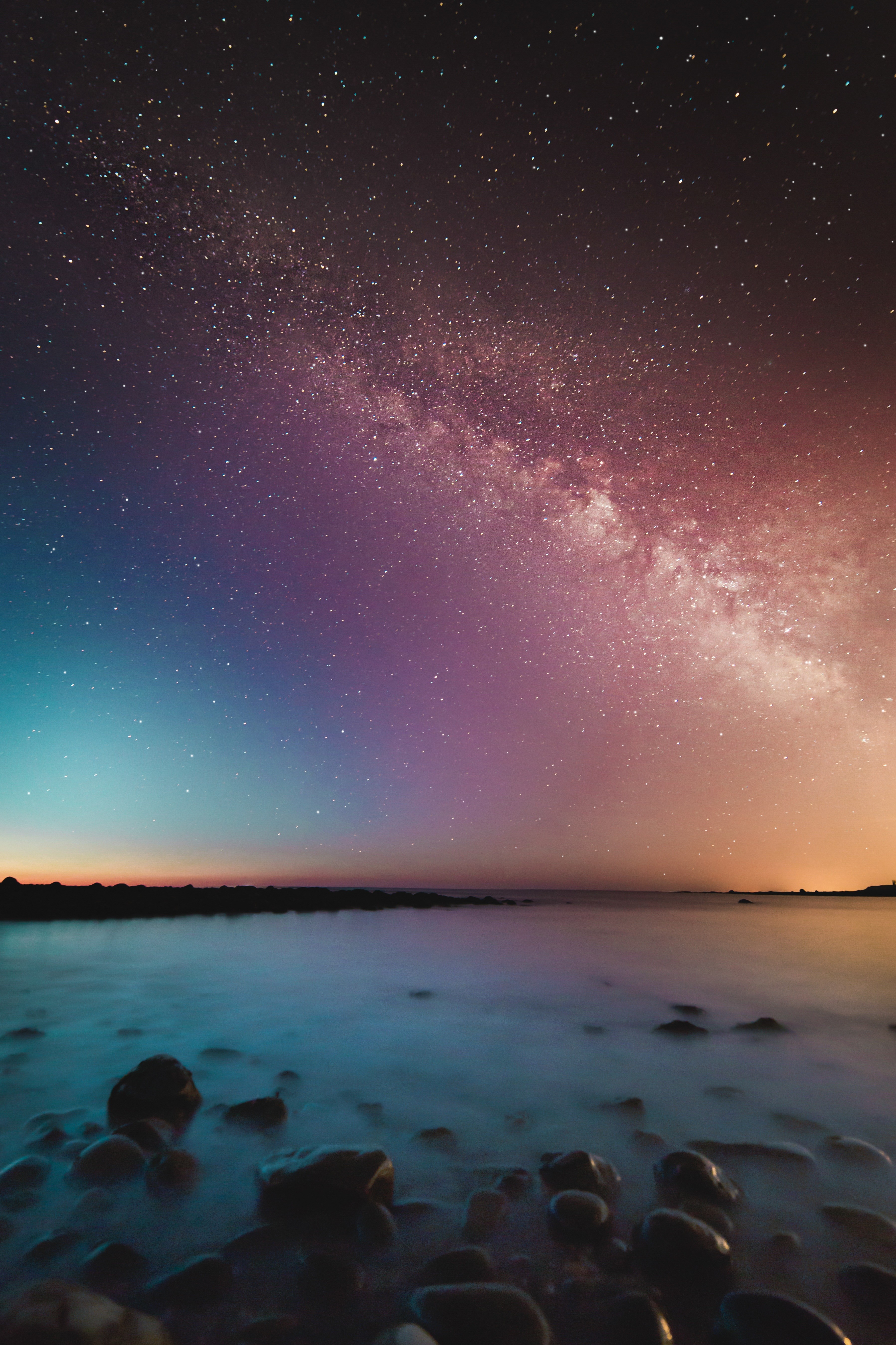 Milky Way galaxy over a rocky shore at night HD Wallpaper