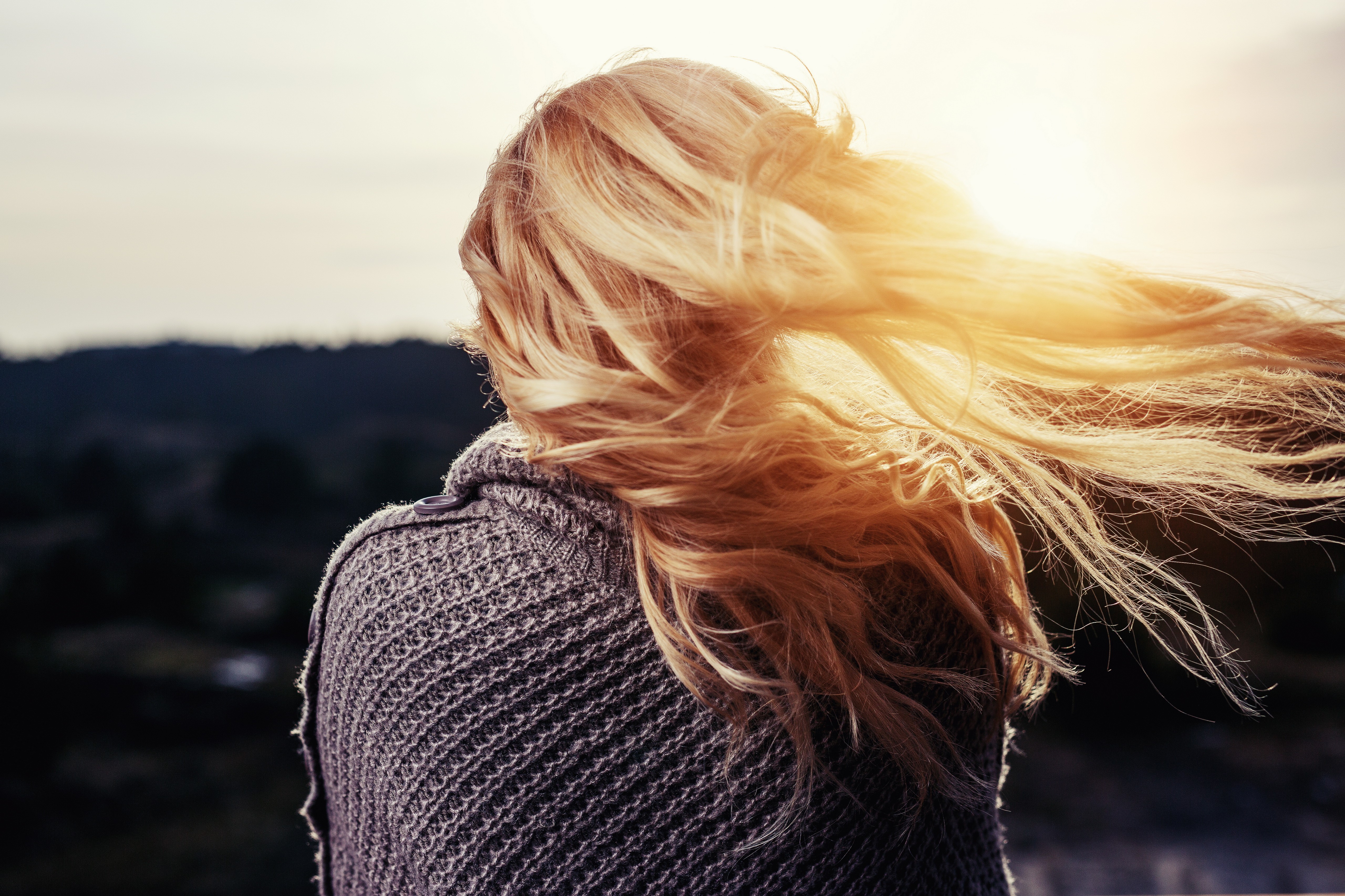 Woman with windblown hair at sunset HD Wallpaper