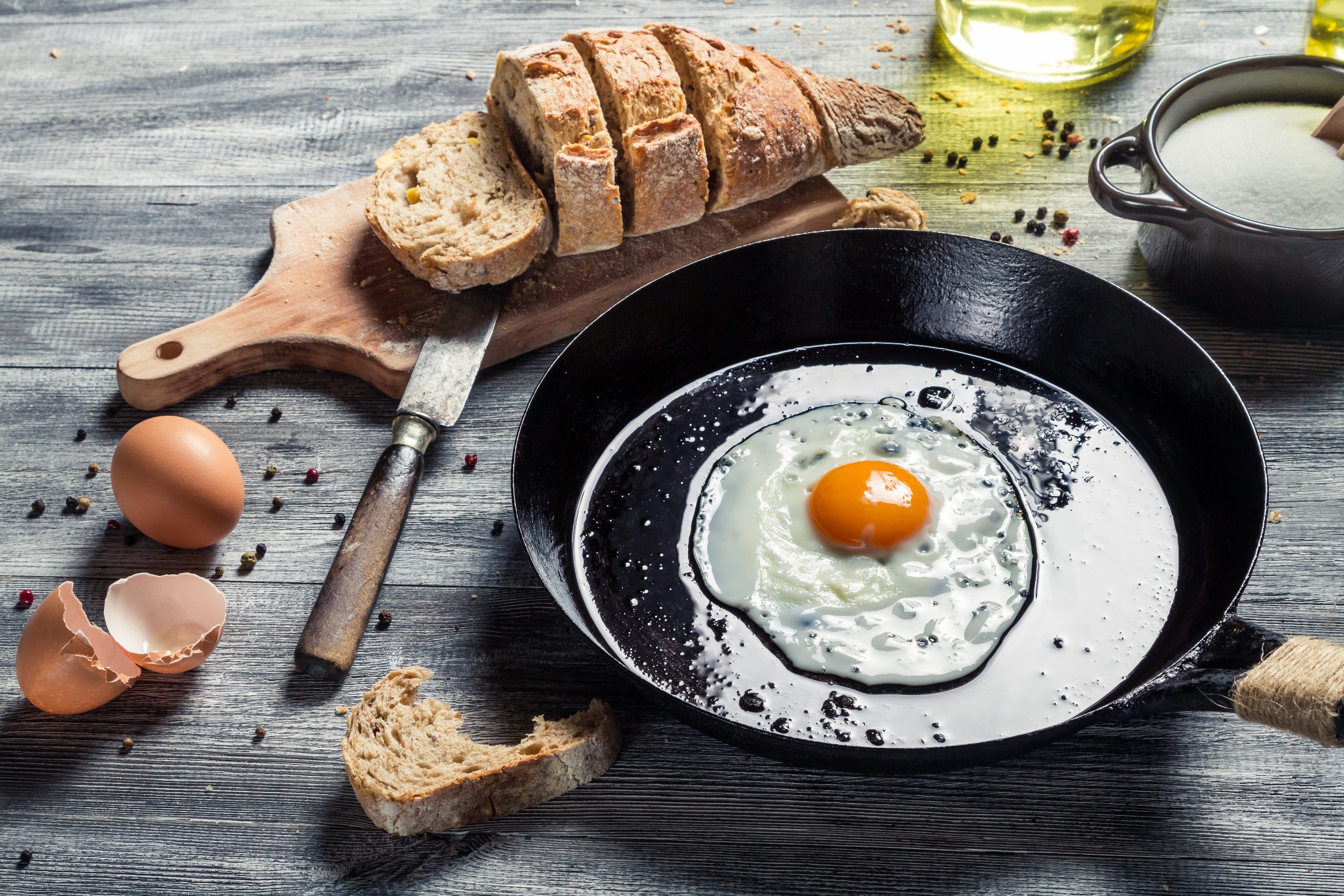 Fried egg in a pan with bread and ingredients HD Wallpaper