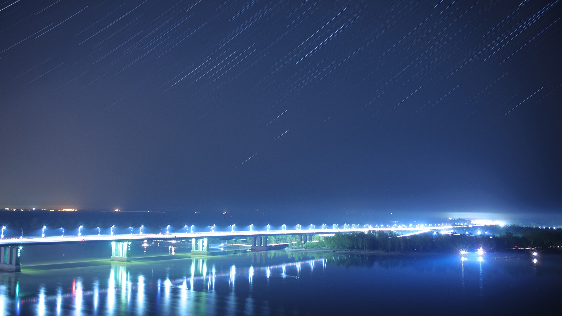 Star trails over a bridge and river at night HD Wallpaper