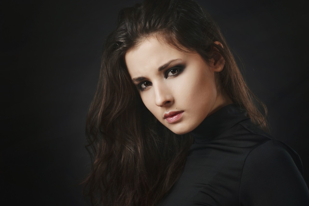 Woman with dark hair and smoky eye makeup HD Wallpaper
