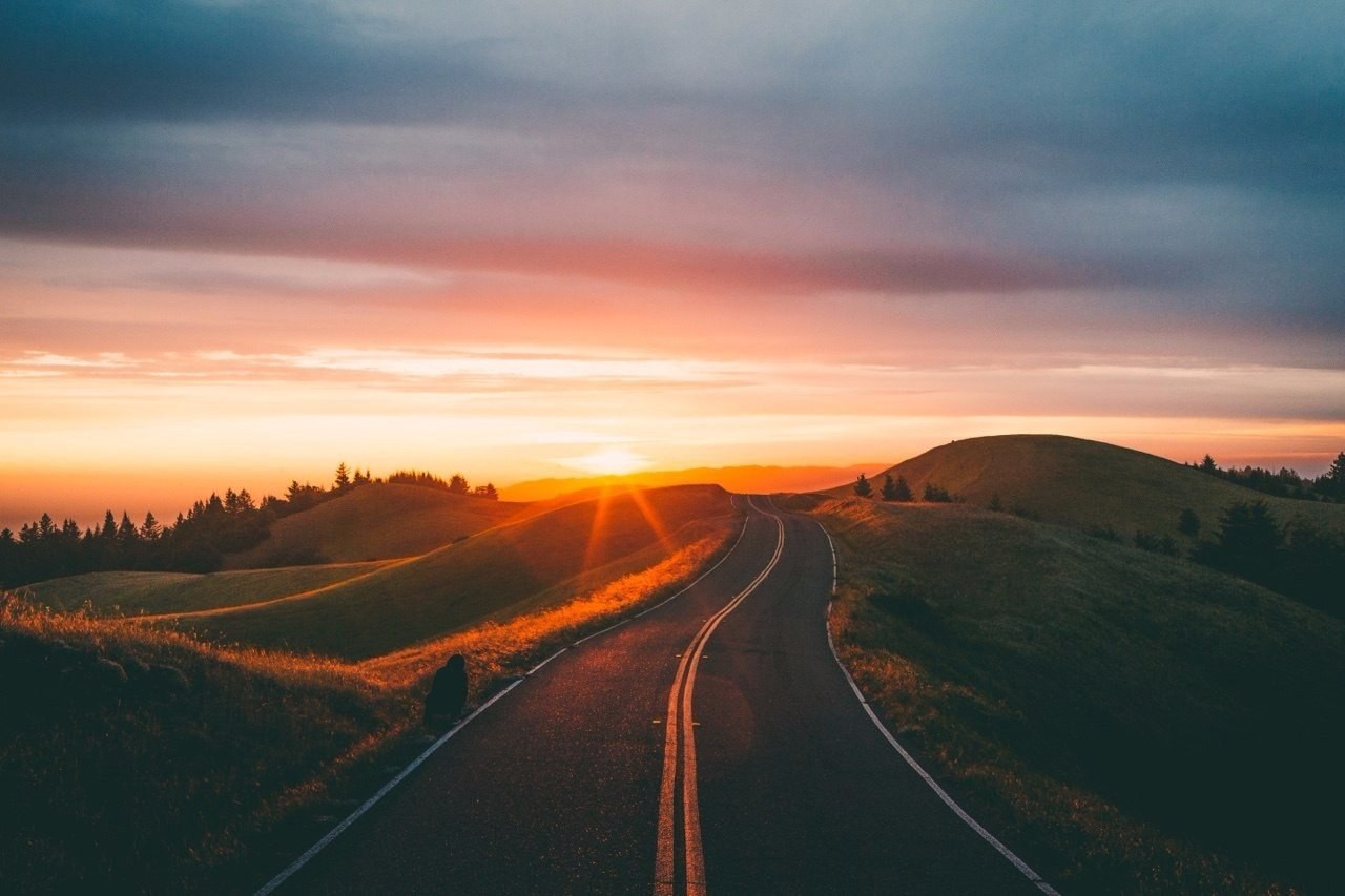 Road through rolling hills at sunset HD Wallpaper