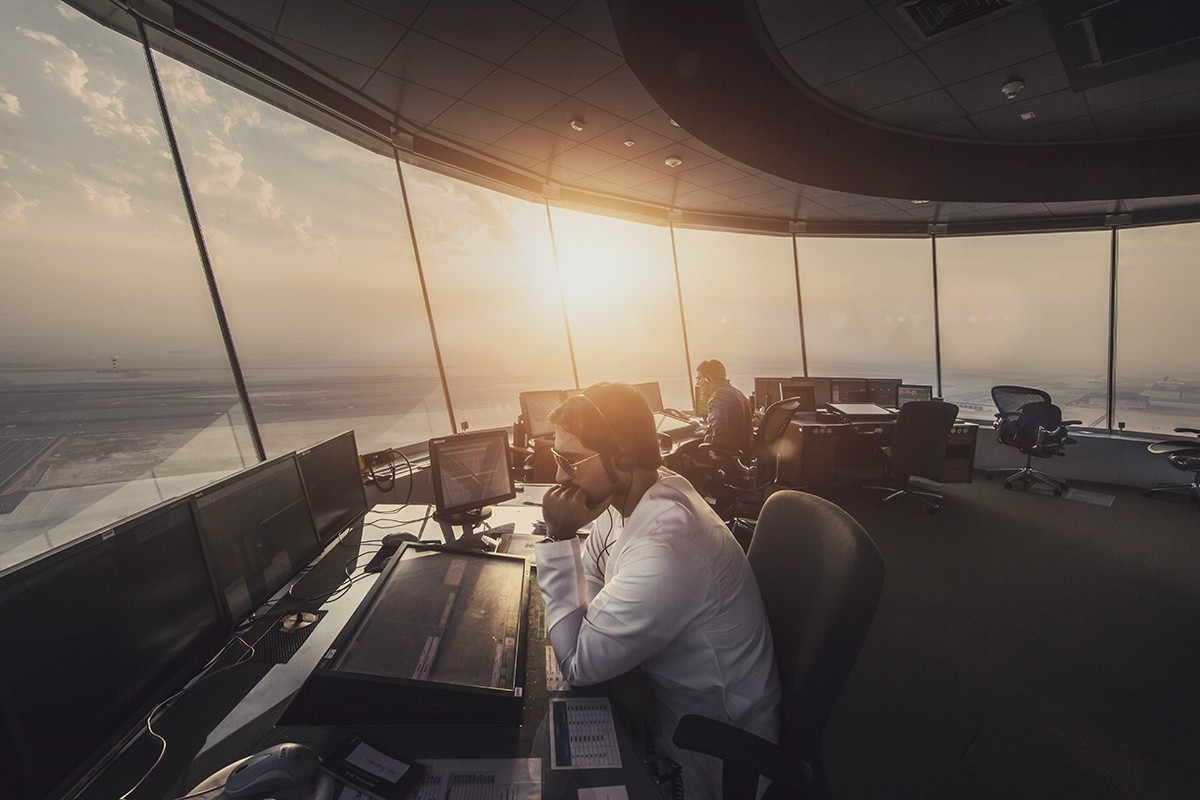Air traffic controllers working in a control tower at sunset HD Wallpaper