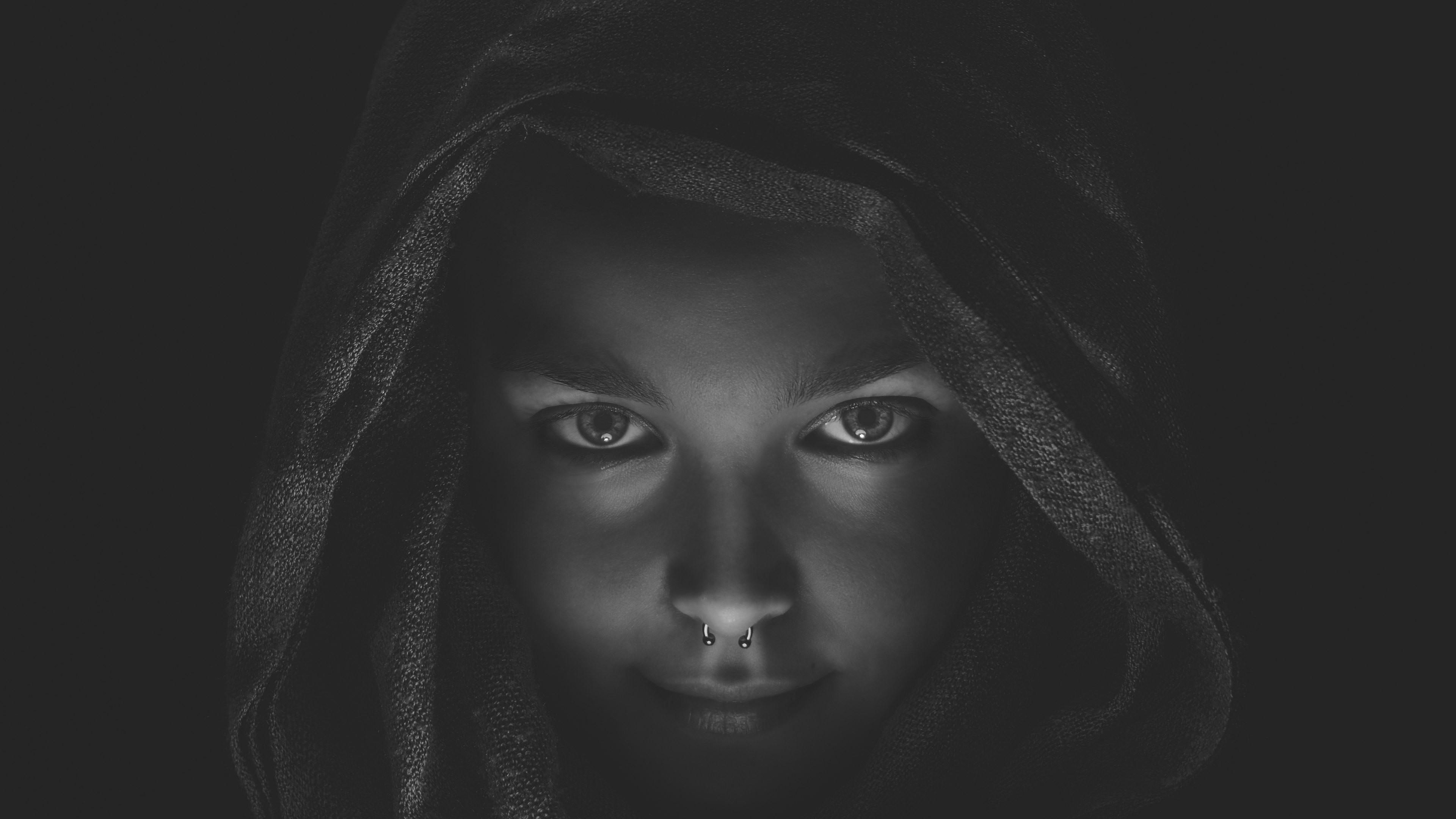 Monochrome portrait of a person with a pierced nose wearing a hood HD Wallpaper