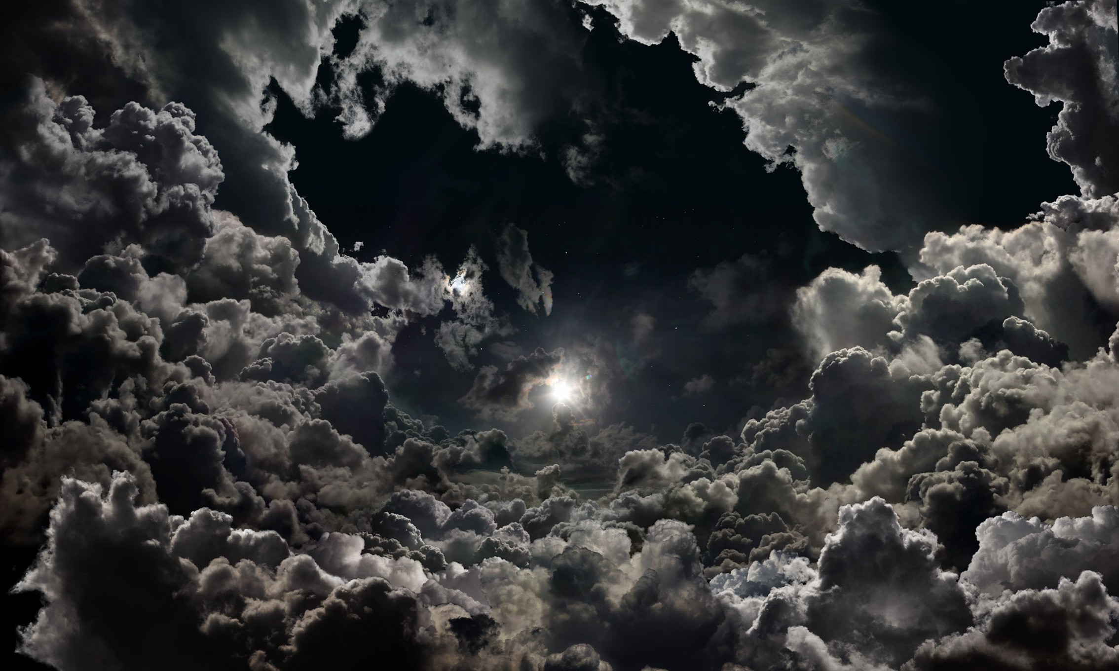 Dark stormy clouds with bright sun peeking through HD Wallpaper