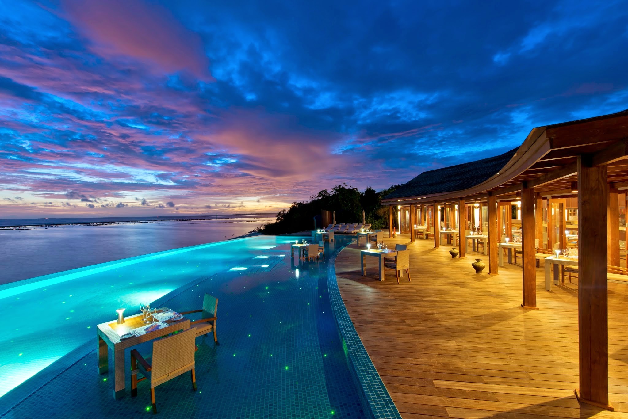 Infinity pool and restaurant at sunset HD Wallpaper