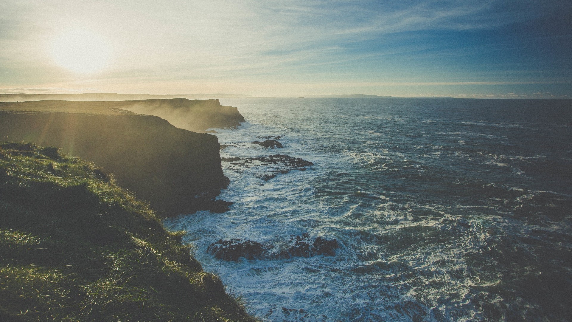 Waves crashing on a cliff coast at sunset HD Wallpaper