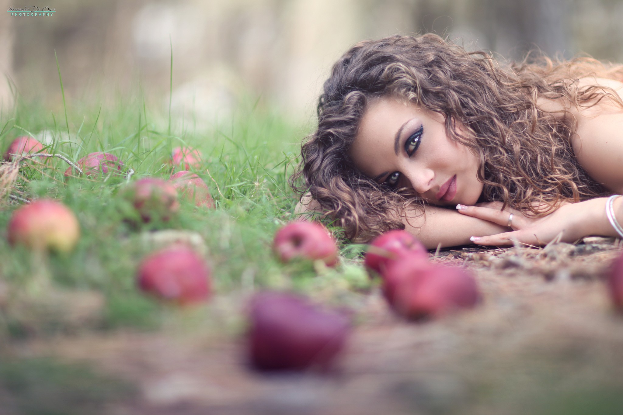 Woman with curly hair lying in grass with apples HD Wallpaper