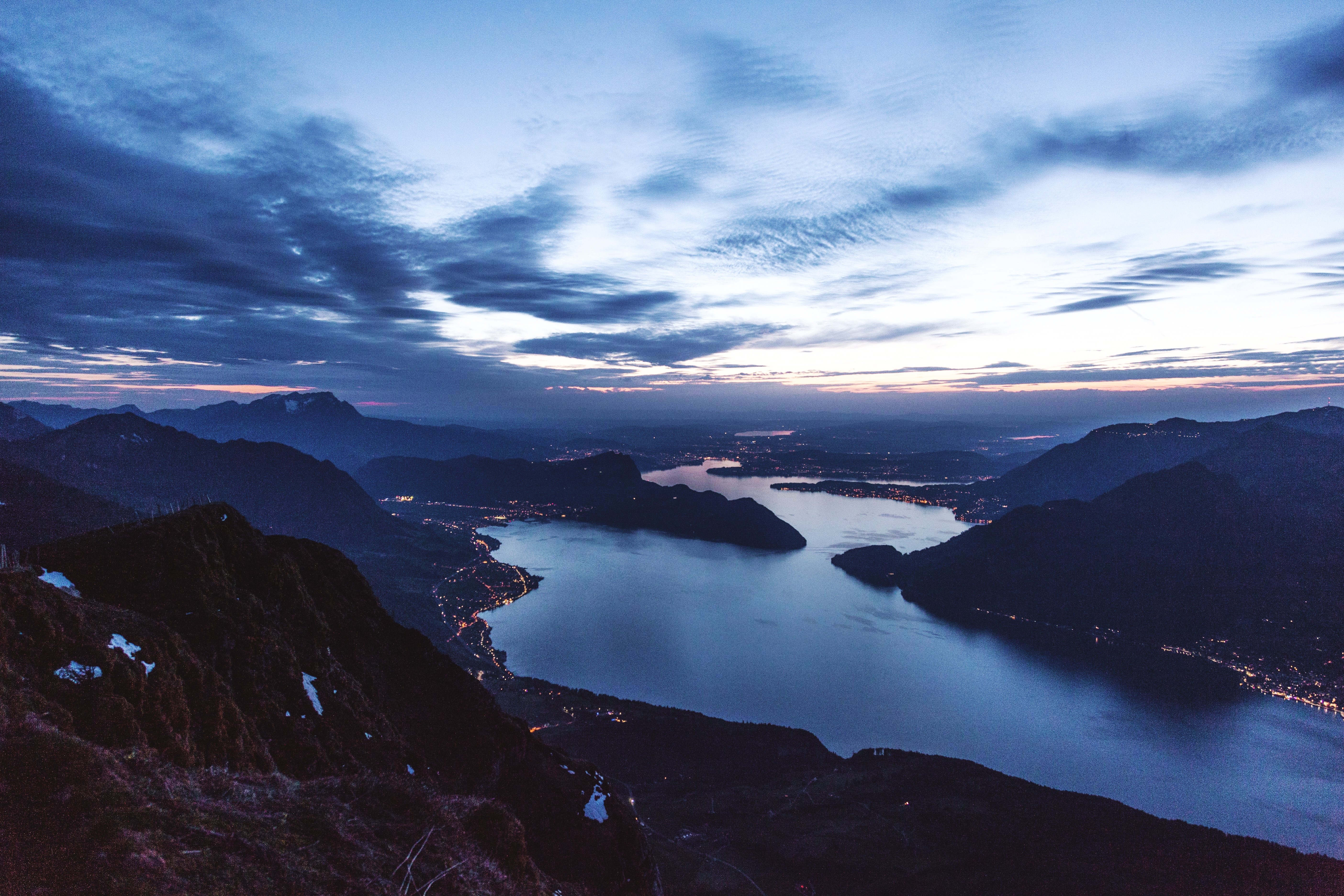 Mountains and lake at dusk with city lights HD Wallpaper
