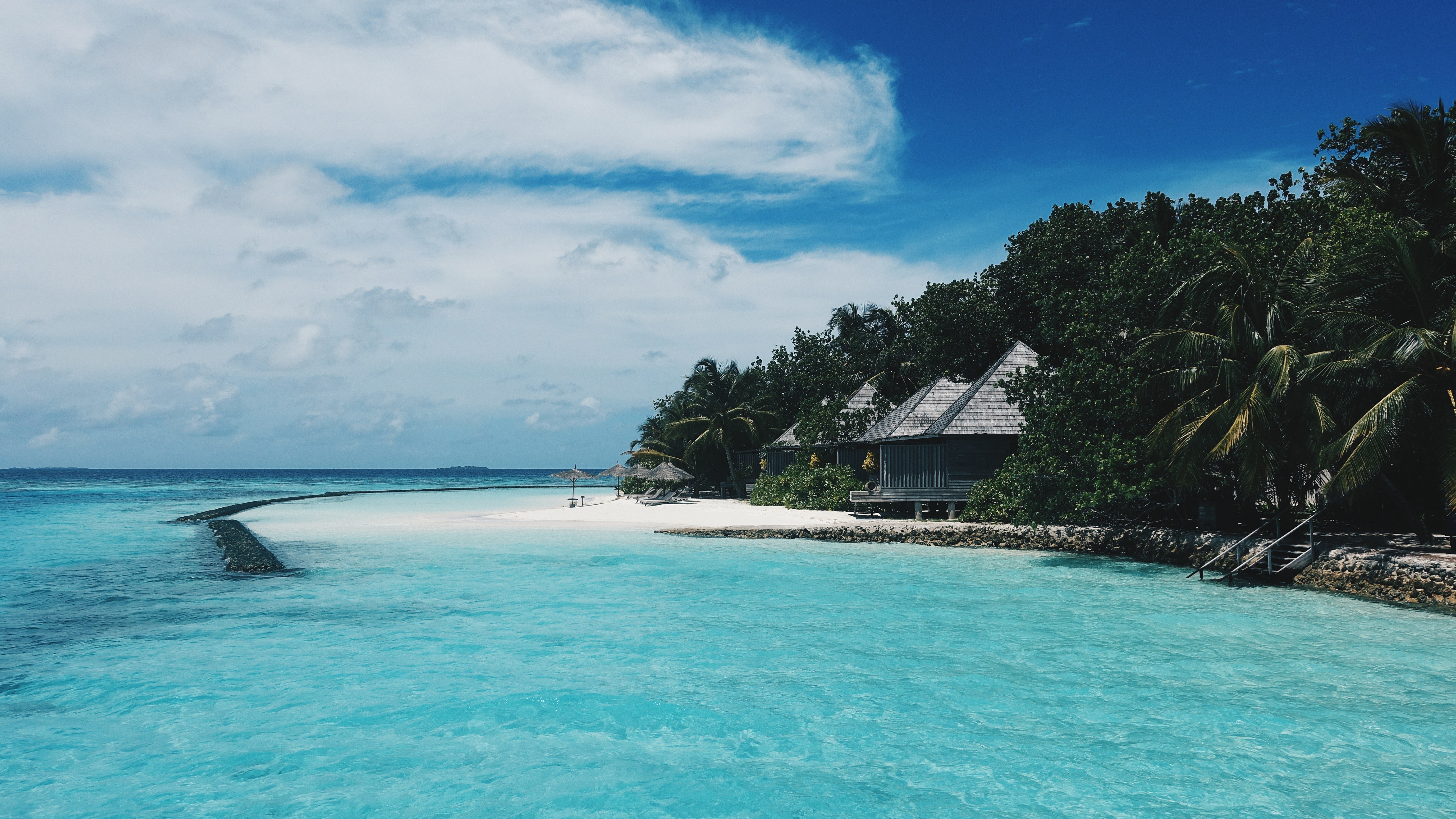 Tropical resort with overwater bungalows and turquoise water HD Wallpaper