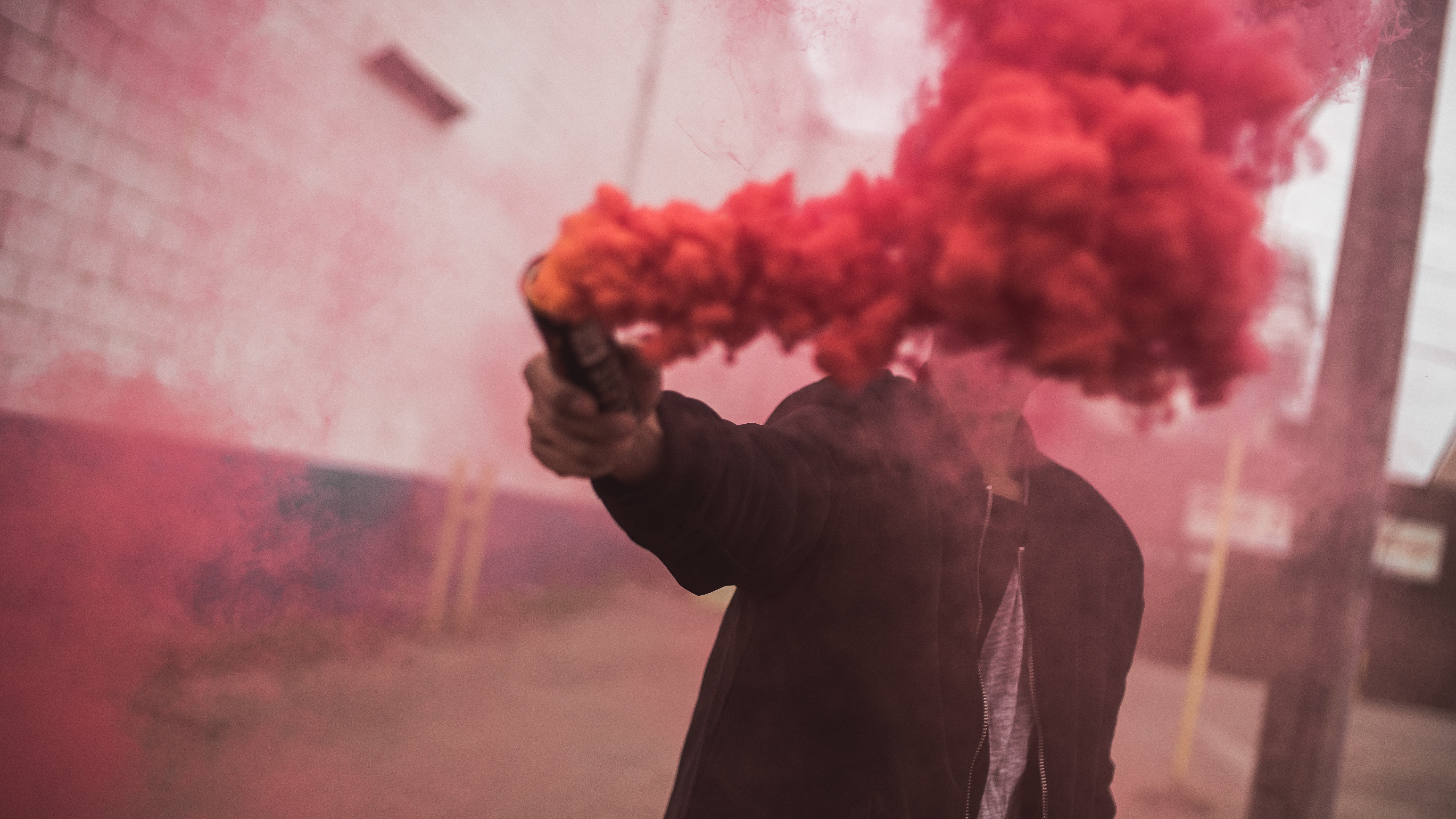 Person holding red smoke bomb HD Wallpaper