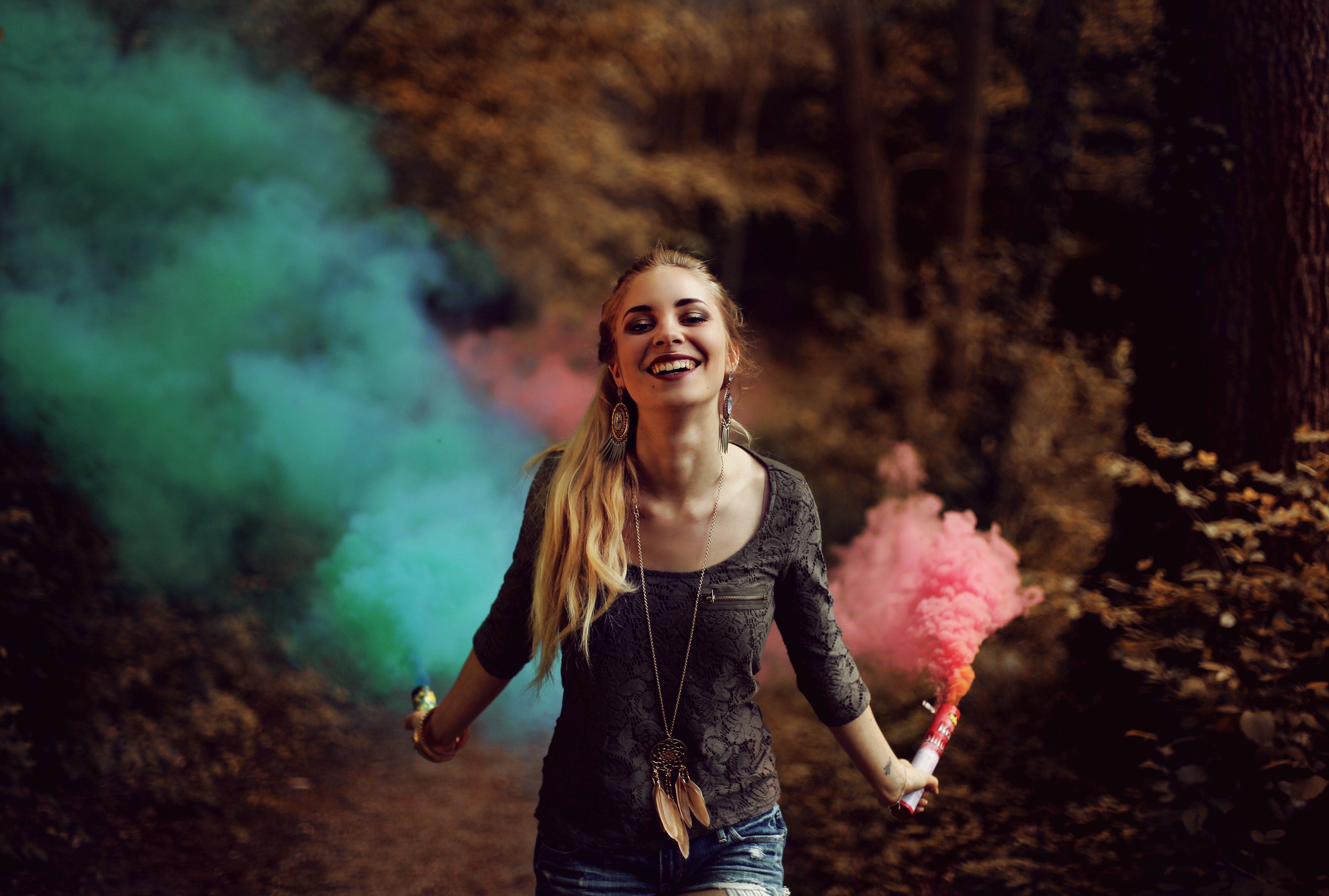 Woman holding smoke bombs in a forest HD Wallpaper