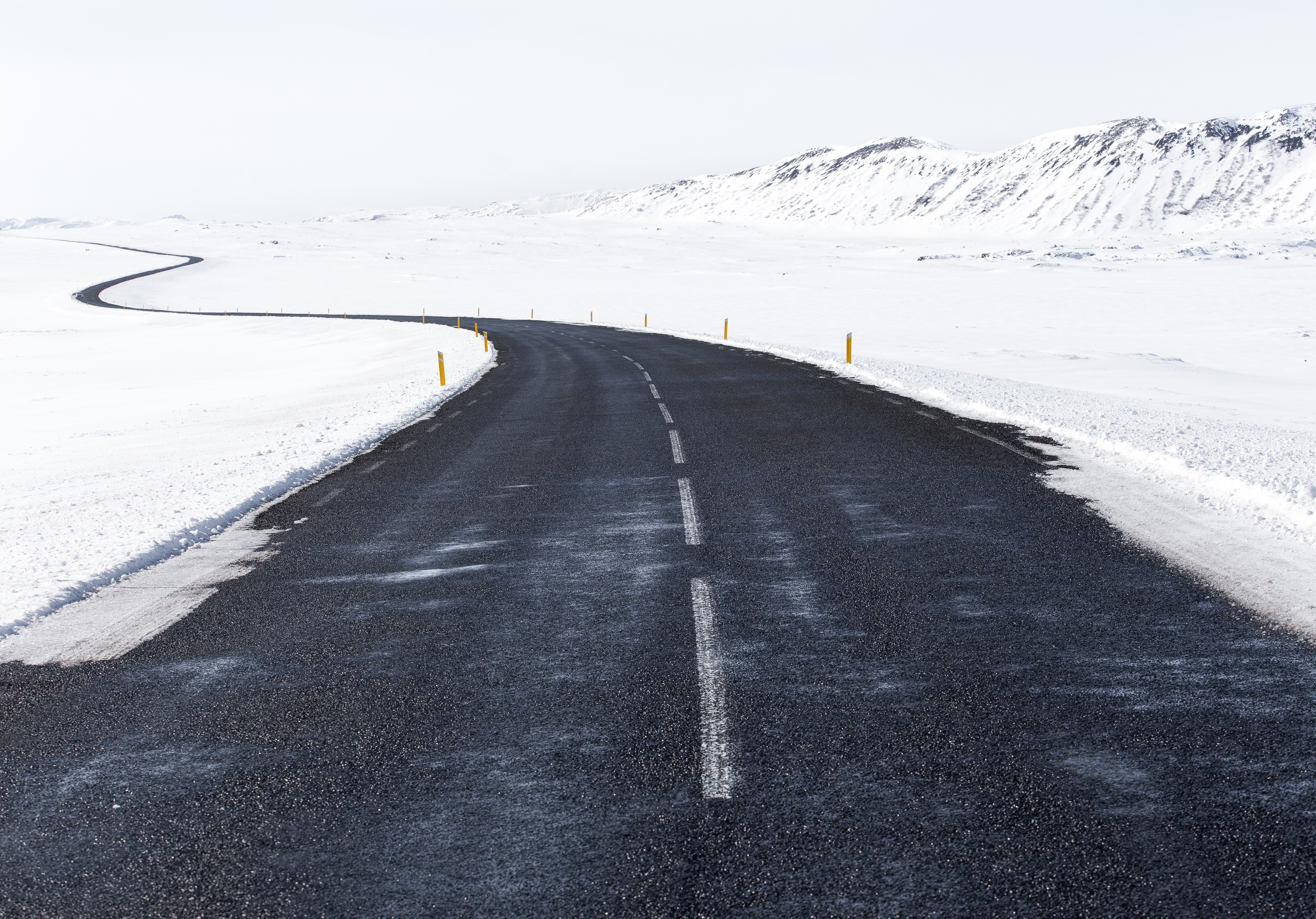 A winding road through a snowy landscape HD Wallpaper