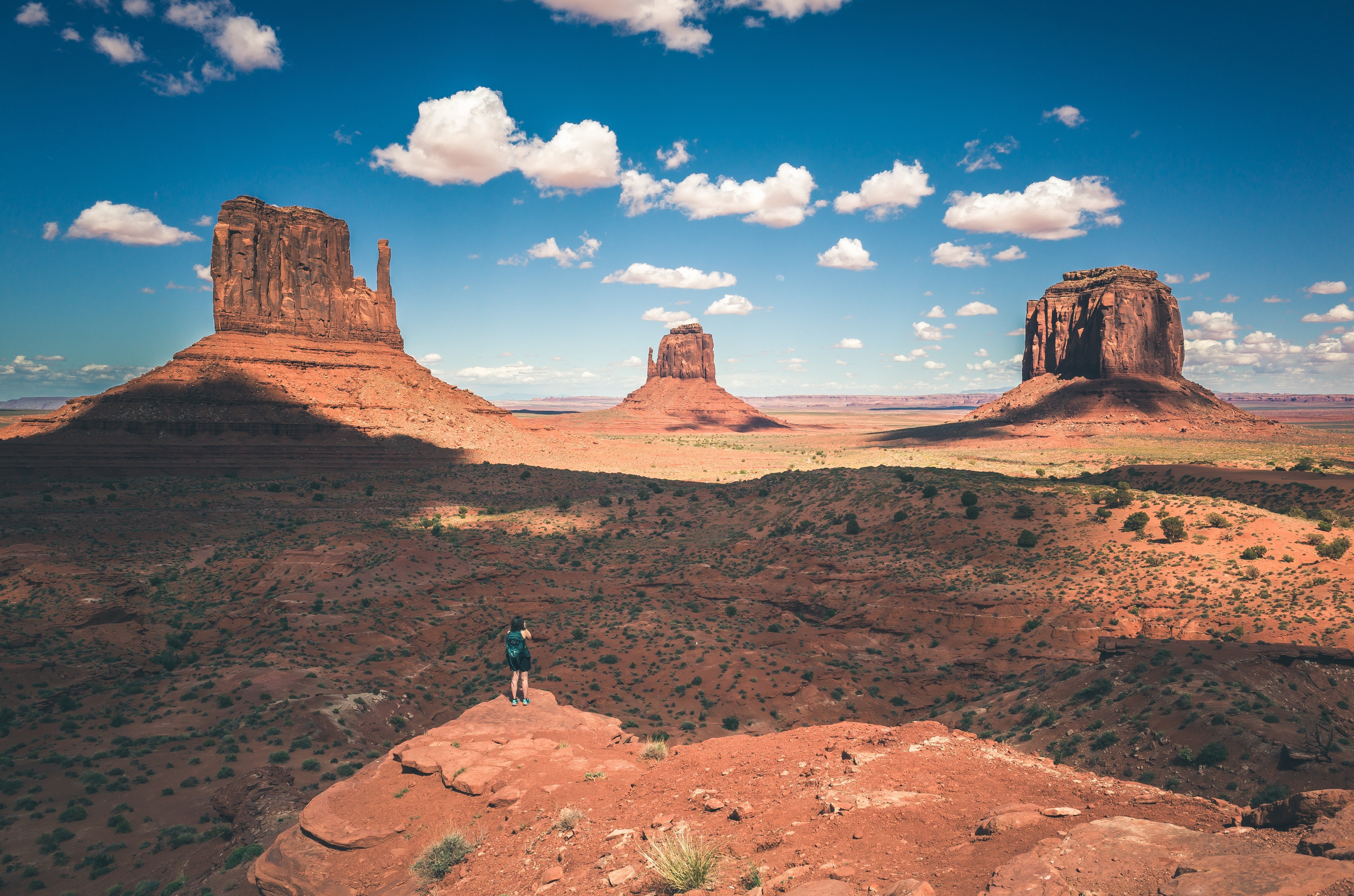Monument Valley landscape with a person on a cliff HD Wallpaper