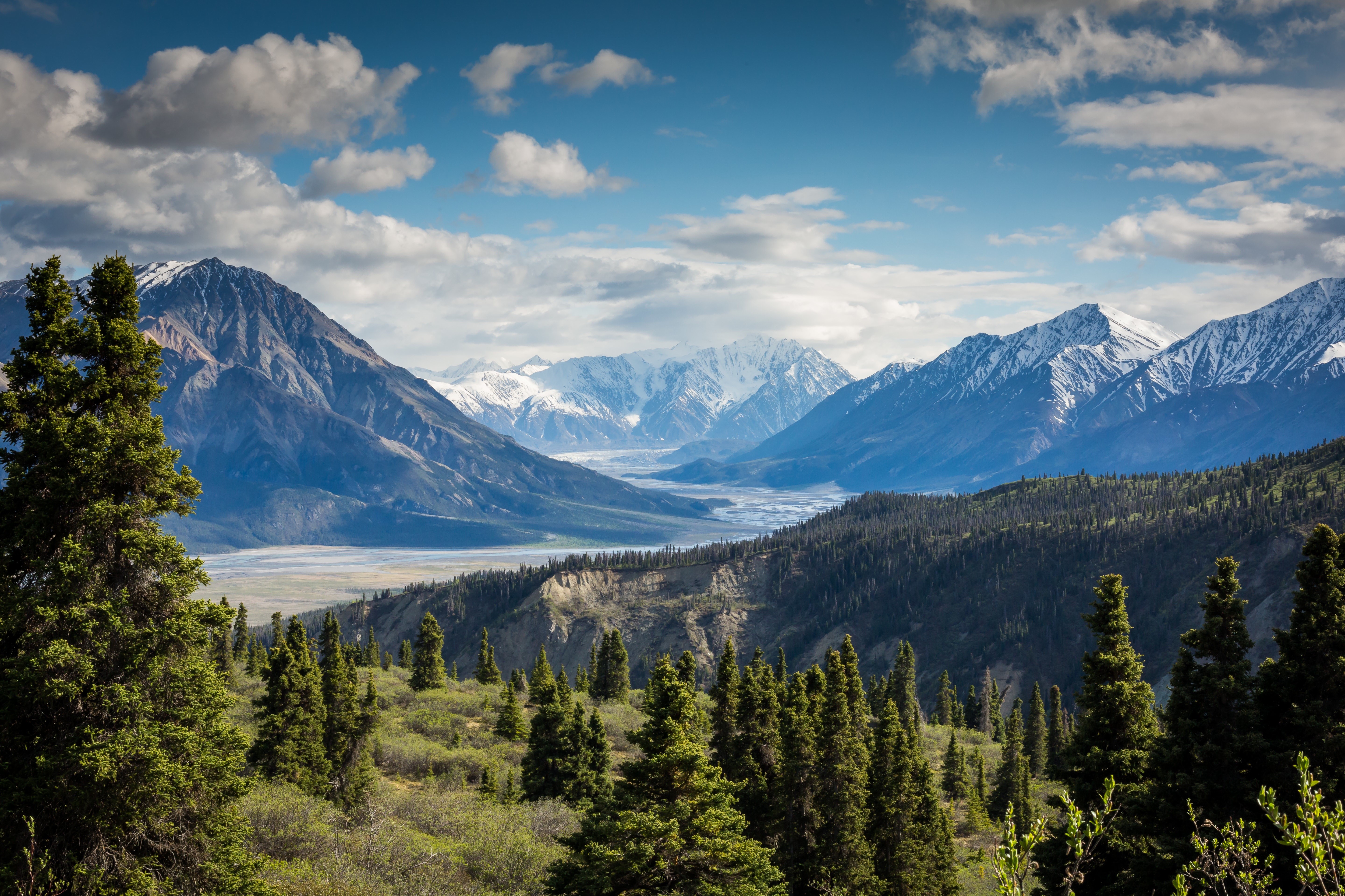 Mountain range with river and trees under cloudy sky HD Wallpaper